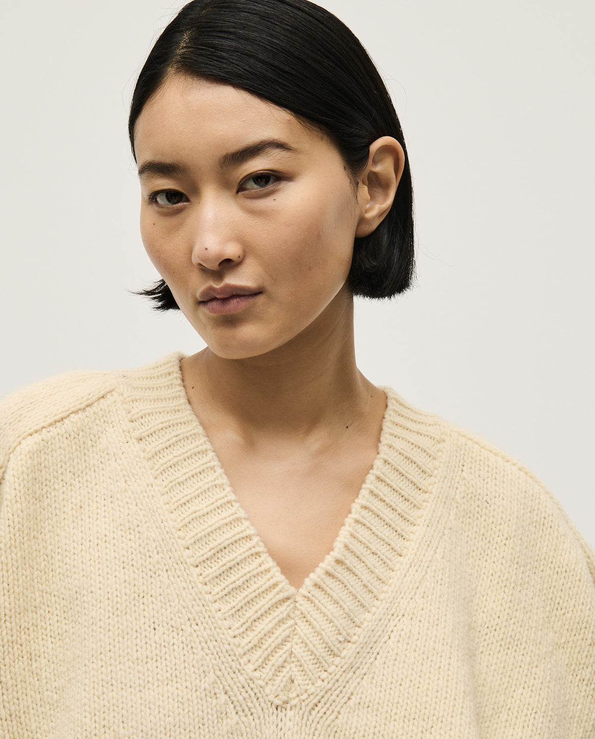 Woman wearing Babaà No29 Natural jumper, showcasing a cozy, neutral-colored knit sweater with a relaxed fit.