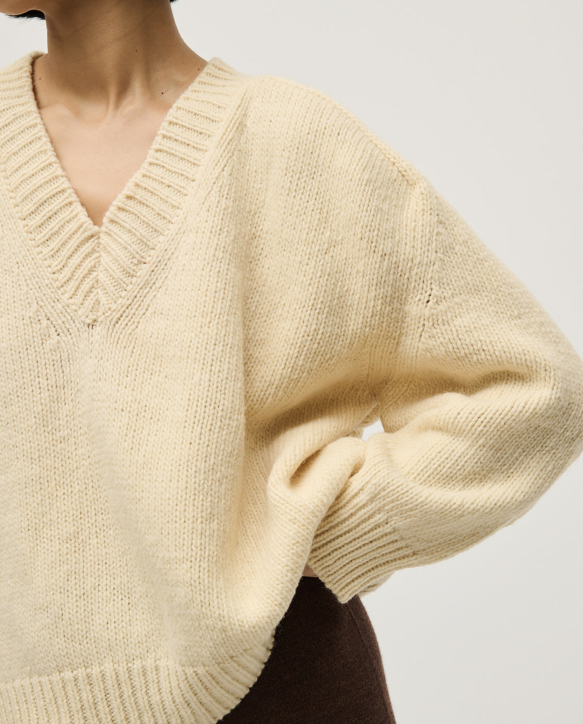 Woman wearing Babaà No29 natural jumper, showcasing a cozy, beige knitted sweater with a relaxed fit and soft texture.