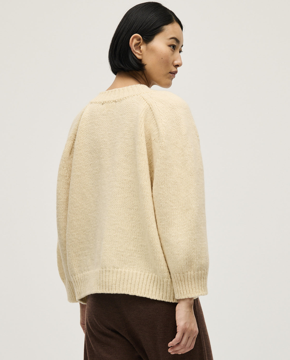 Woman wearing Babaà No29 natural jumper, soft beige knit sweater with a relaxed fit, styled for casual wear.