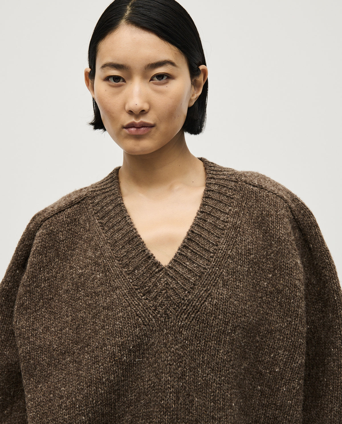 Woman wearing Babaà No29 Oak jumper, featuring a cozy knit design in warm oak color, perfect for casual winter outfits.