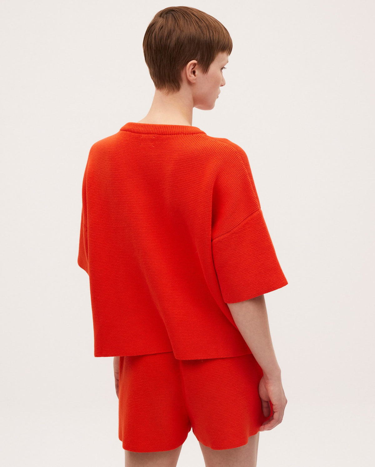Woman wearing Babaà no35 Tangelo jumper, featuring a cozy, vibrant orange knit sweater with a relaxed fit.