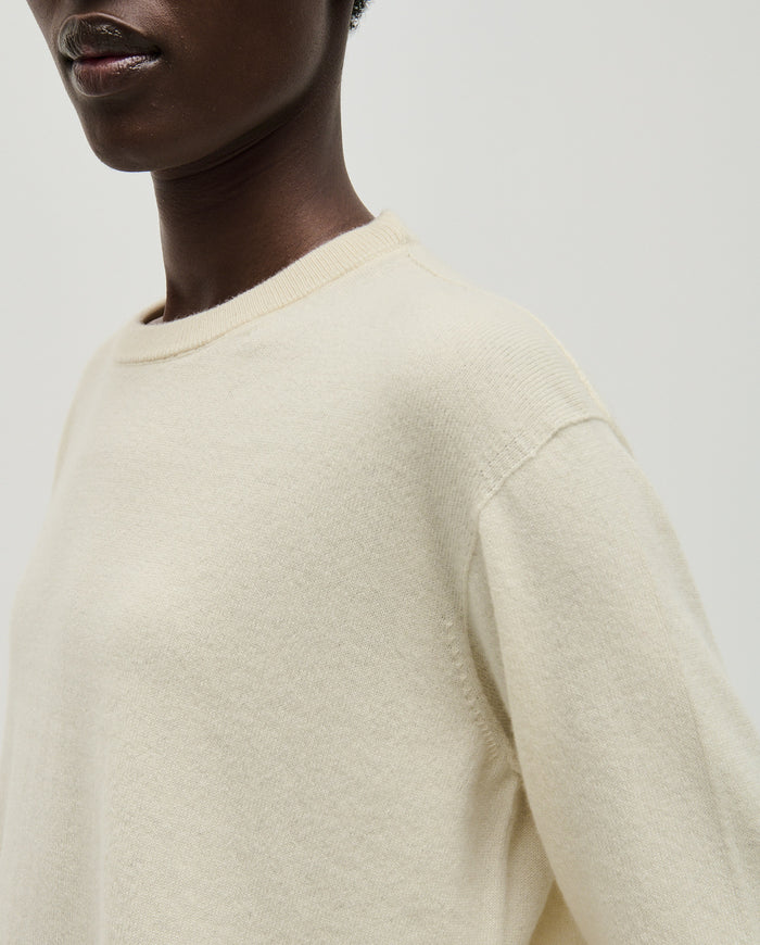Woman wearing Babaà No41 natural jumper, showcasing its cozy, neutral-toned knit design and relaxed fit.