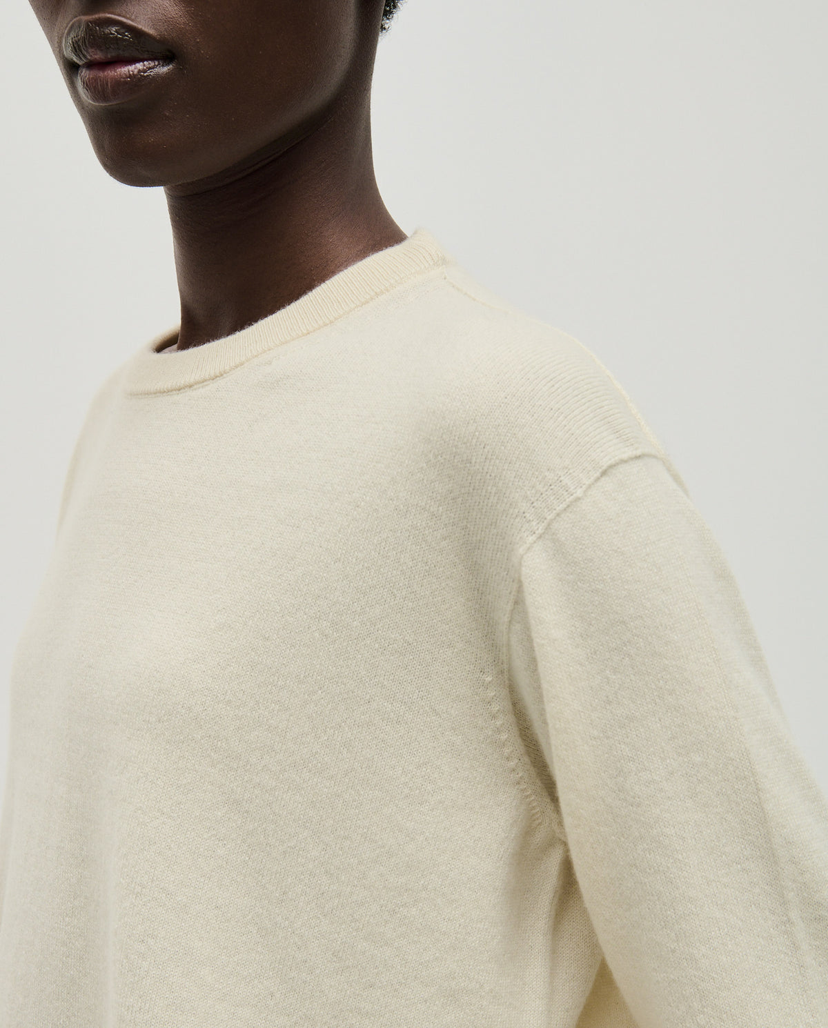 Woman wearing Babaà No41 natural jumper, showcasing its cozy, neutral-toned knit design and relaxed fit.