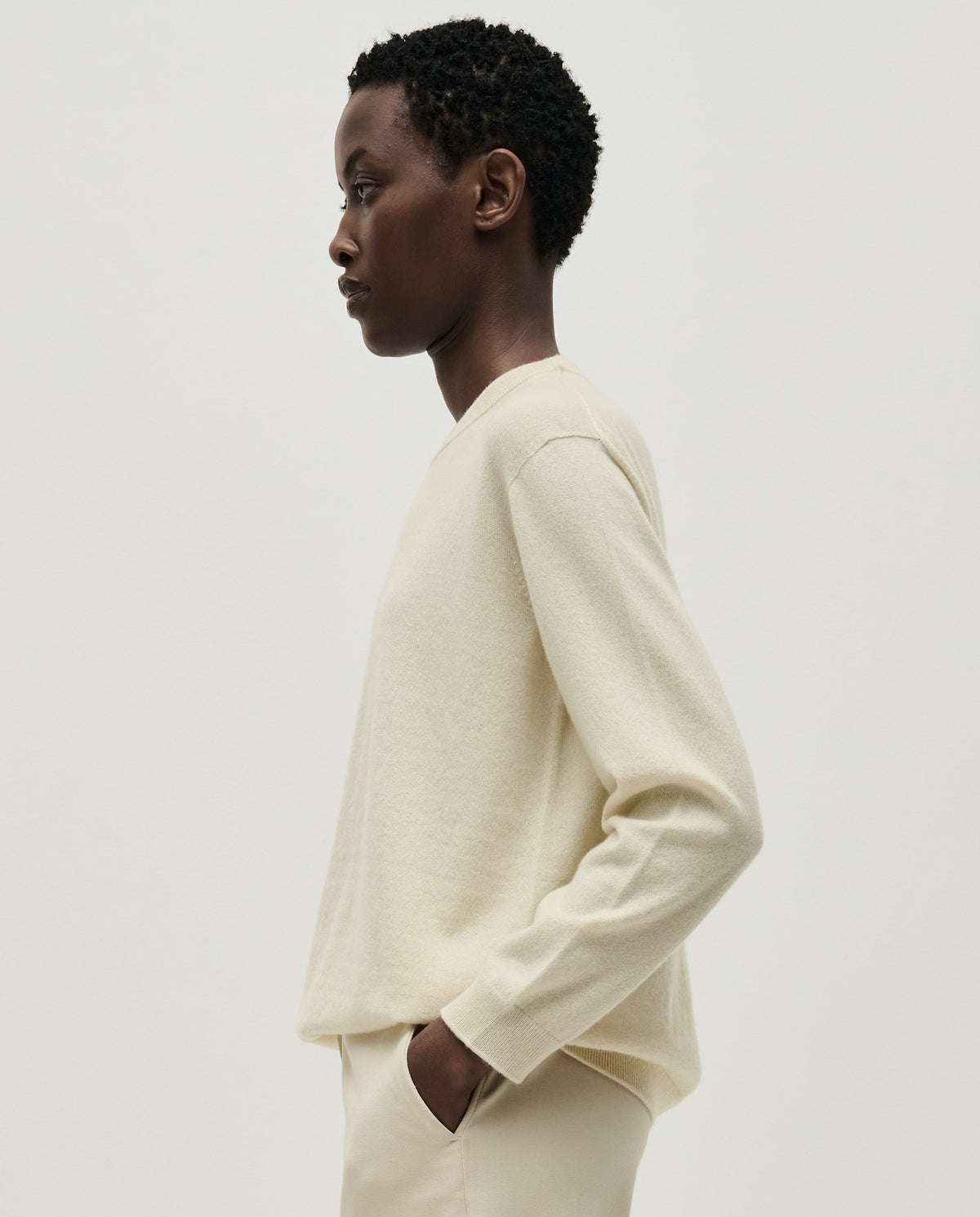 Woman wearing Babaà No41 natural jumper, cozy knit sweater in a neutral beige color, styled casually.