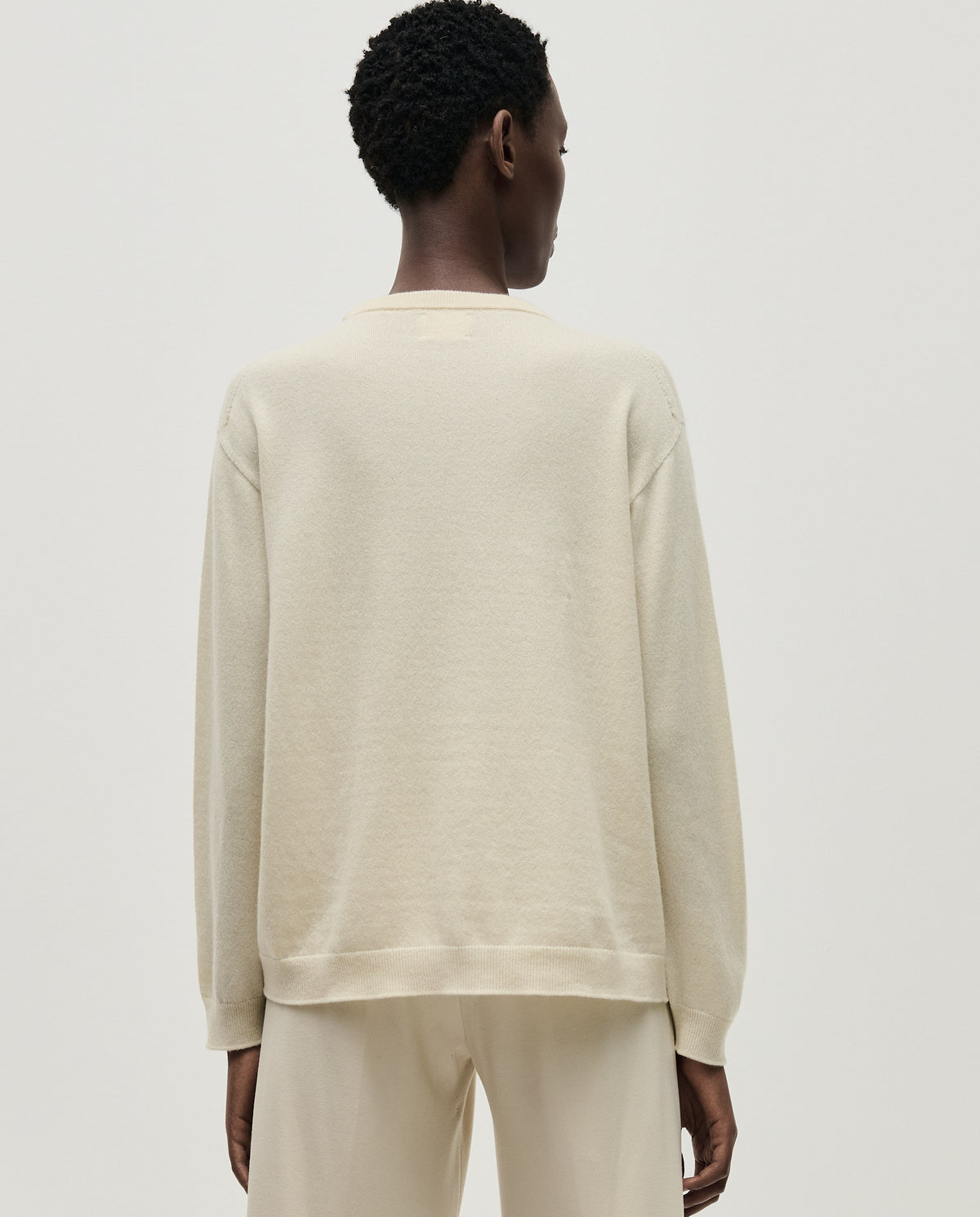 Woman wearing Babaà No41 natural jumper, showcasing its cozy knit texture and relaxed fit in a natural color.