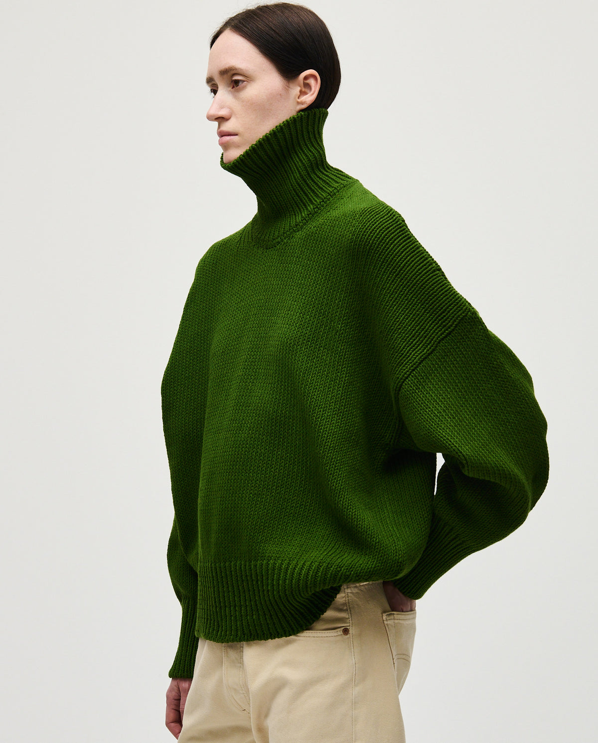 Woman wearing Babaà No42 pine jumper, showcasing a cozy, stylish knit sweater in soft pine green.