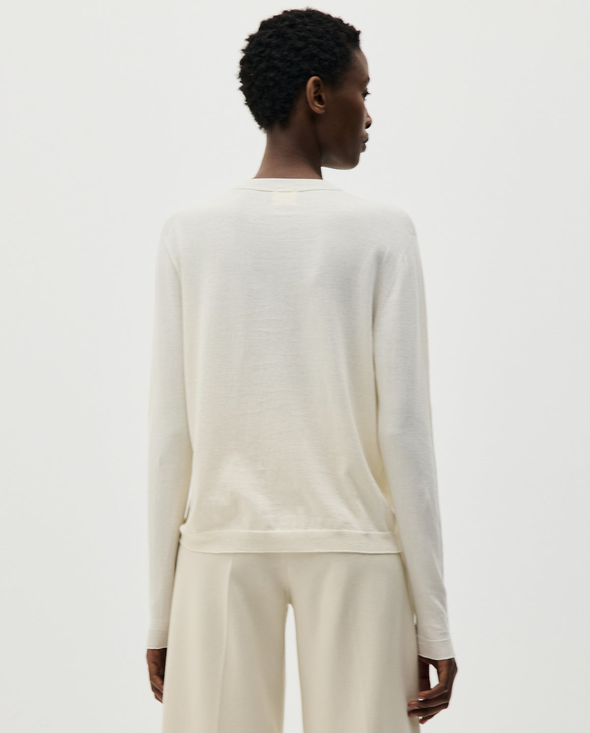 Woman wearing Babaà No50 Natural jumper, showcasing the soft, relaxed fit and natural beige color of the knit sweater.
