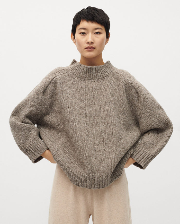 Babaà jumper No51 in dark mist color, worn by a woman, showing a cozy knit sweater with a high neckline and relaxed fit.