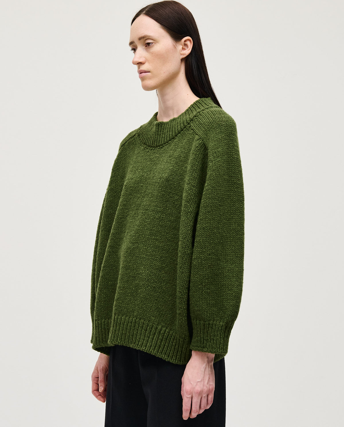 Woman wearing Babaà No51 Forest jumper, featuring a cozy knit design in earthy forest green.