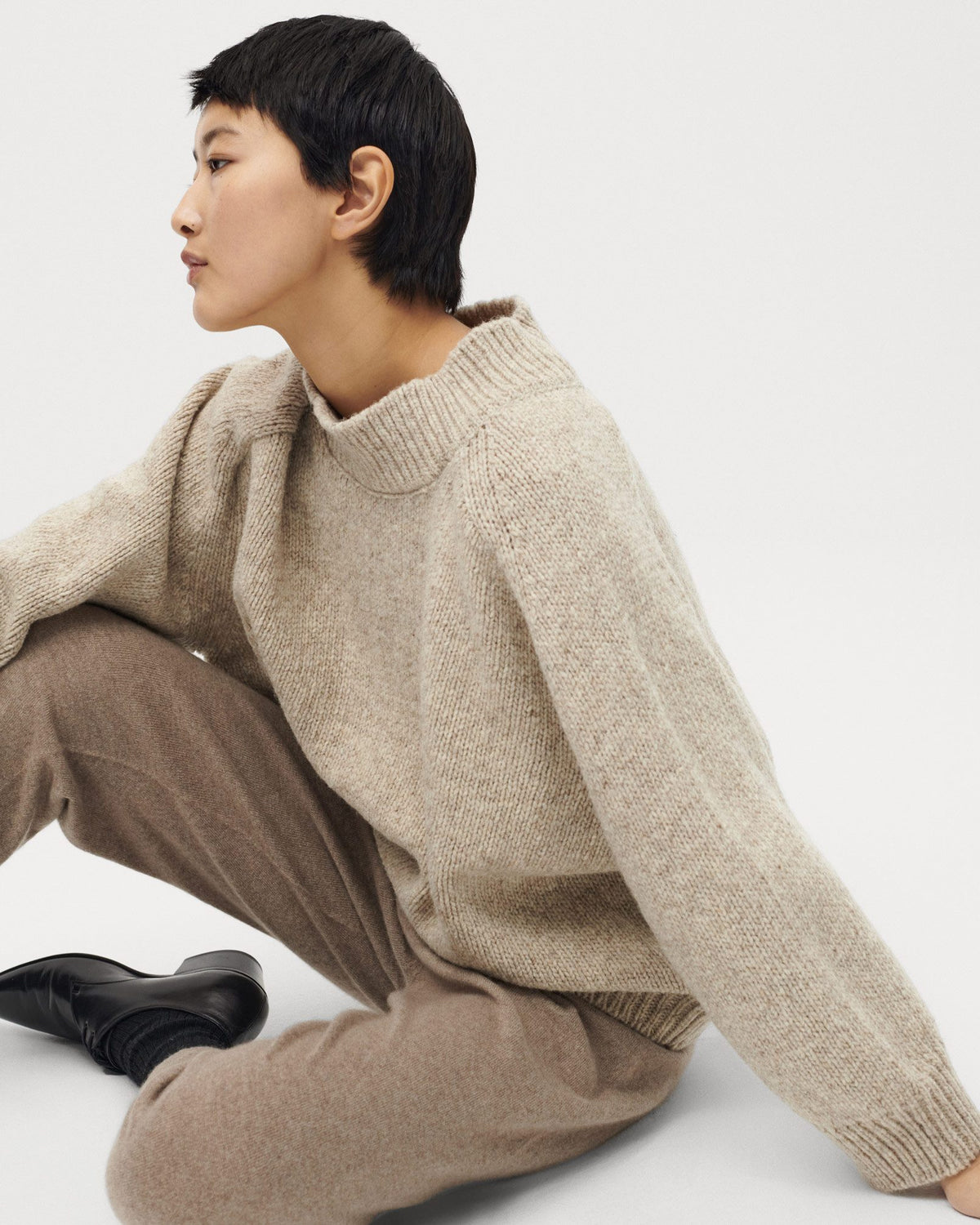 Woman wearing Babaà No51 Mist jumper, showcasing a cozy, stylish knit sweater in soft, neutral tones.
