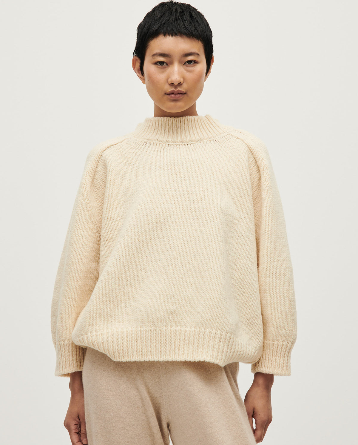 Woman wearing Babaà No51 natural jumper, soft knit sweater with a relaxed fit and neutral beige color, perfect for casual wear.