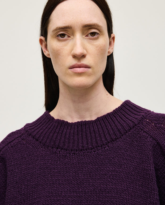 Woman wearing Babaà No51 purple jumper, featuring a cozy fit and knit texture, styled casually for a comfortable look.