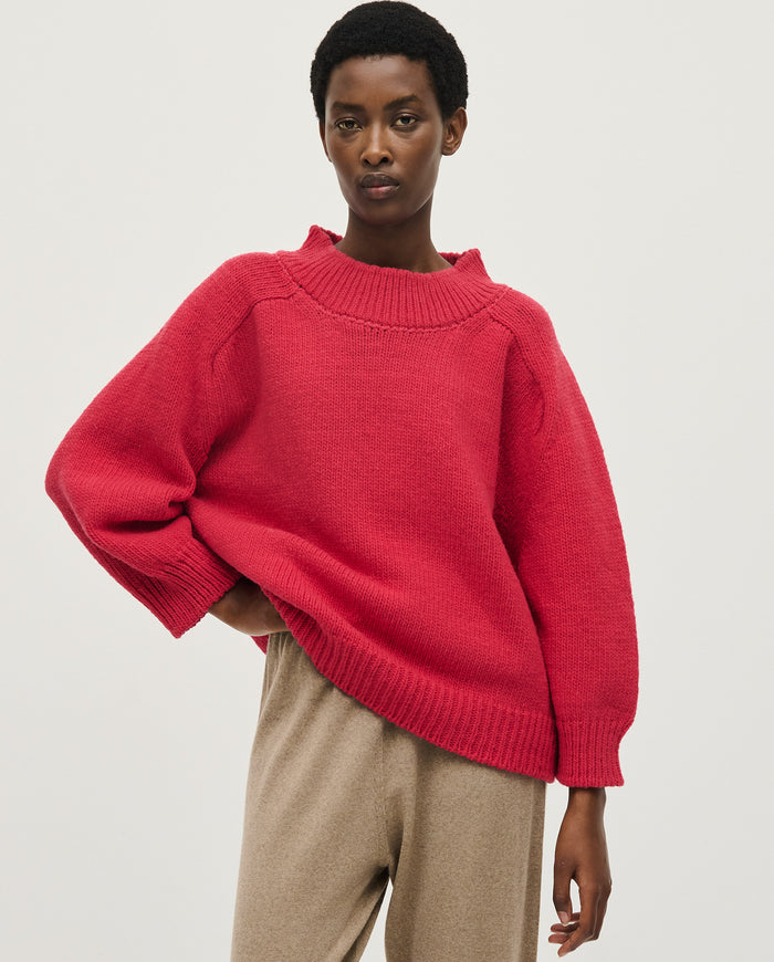 Woman wearing Babaà No51 Ruby jumper, featuring a cozy red knit design, shown in a front view.