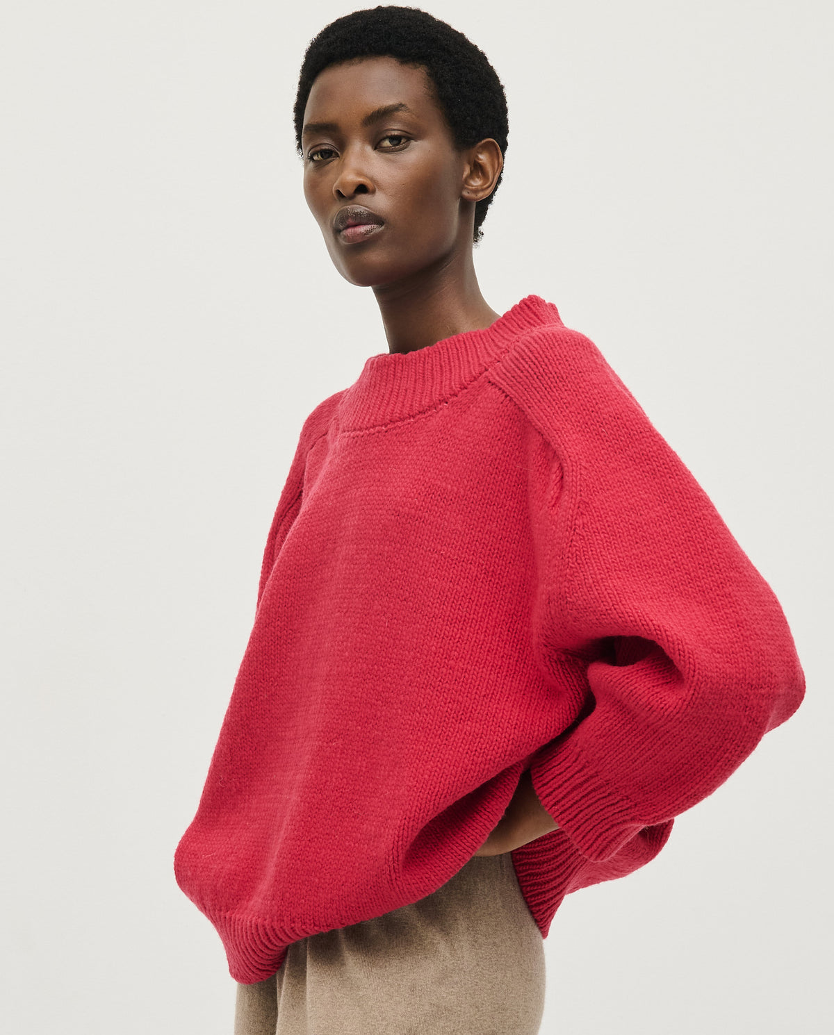 Woman wearing Babaà No51 Ruby jumper, showcasing its cozy fit and vibrant red color, perfect for casual and stylish outfits.