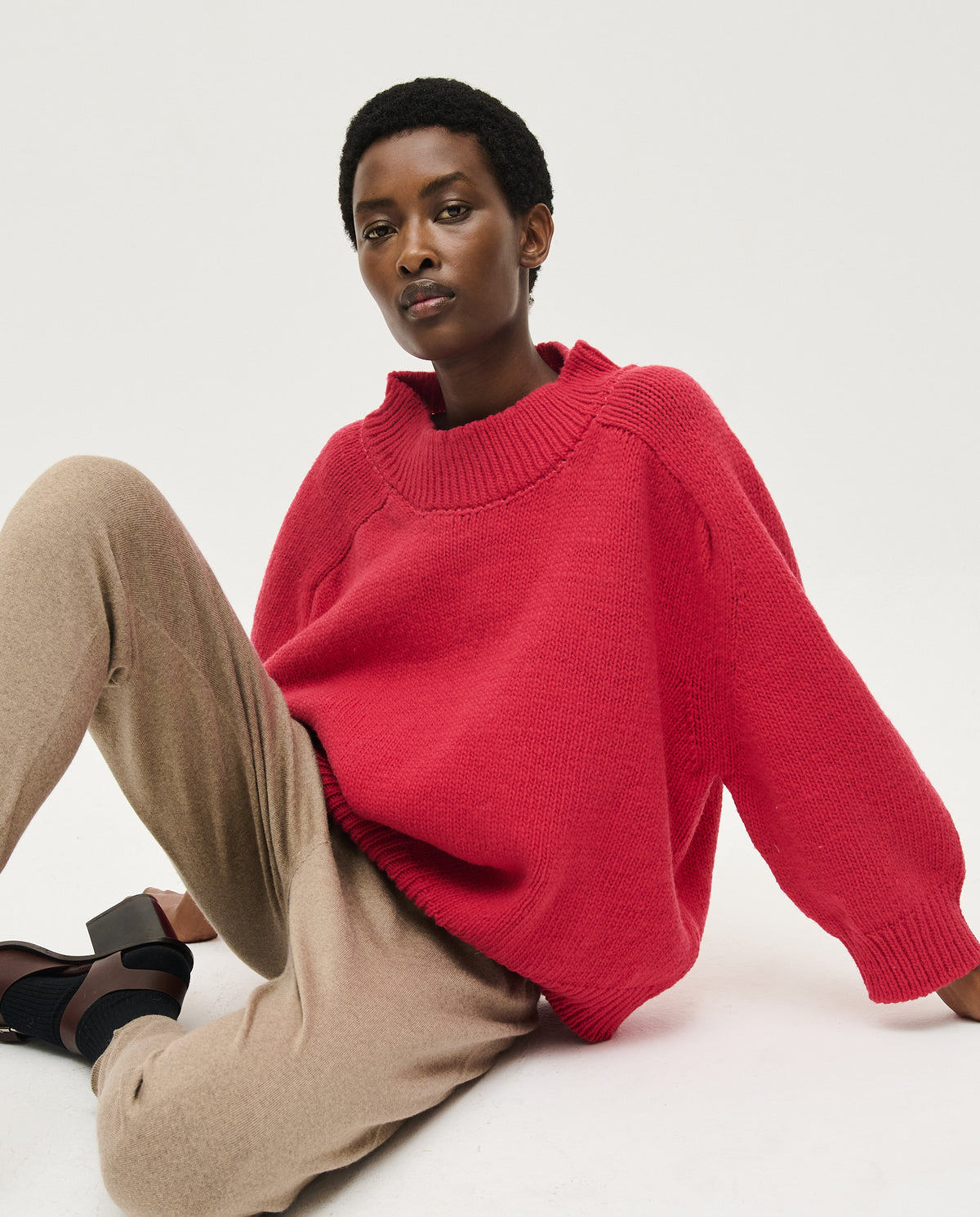 Woman wearing Babaà No51 Ruby jumper, featuring a cozy, vibrant red knit with a relaxed fit and stylish design.