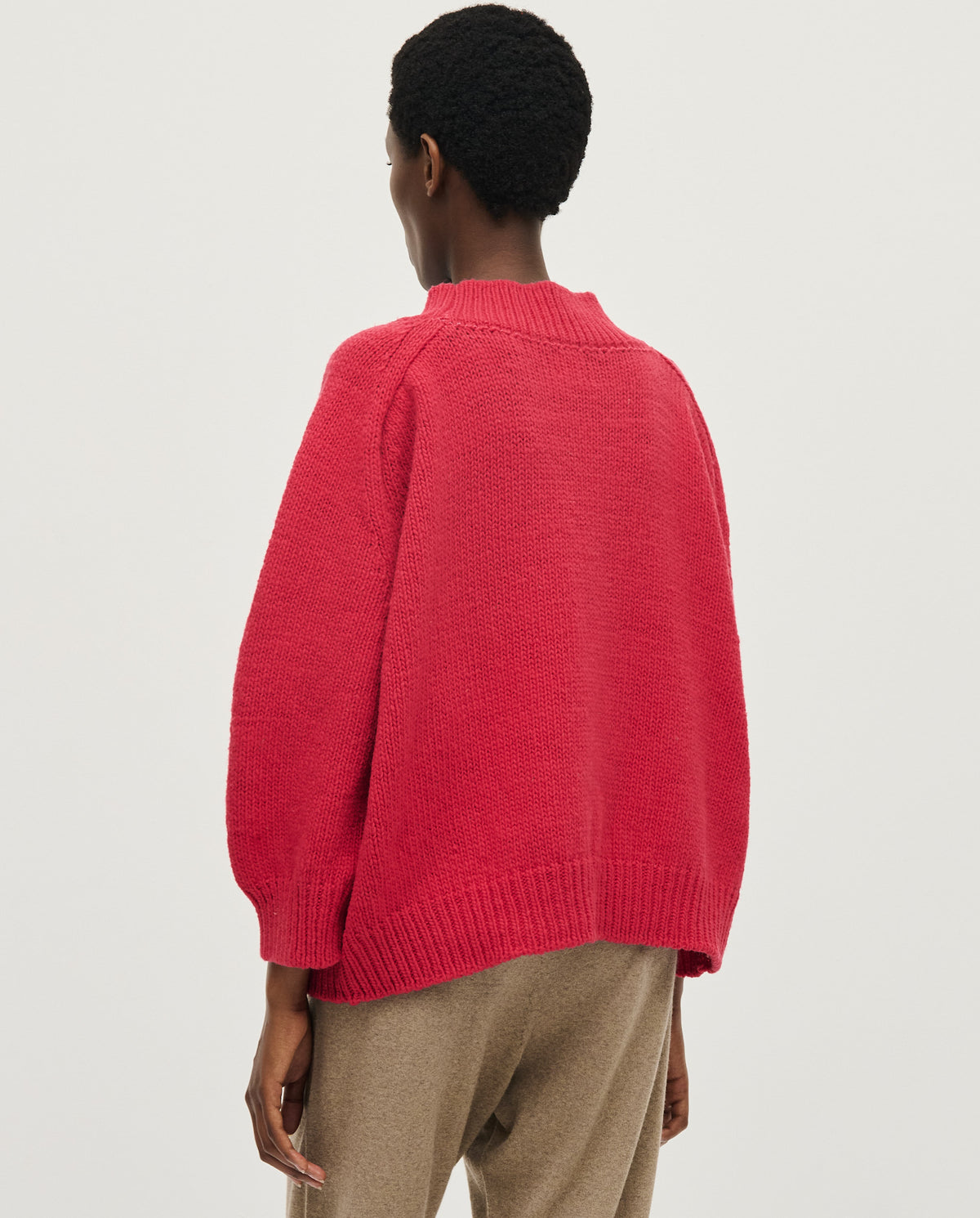 Woman wearing Babaà No51 Ruby jumper, featuring a cozy, fitted design in vibrant ruby red, suitable for casual or stylish wear.