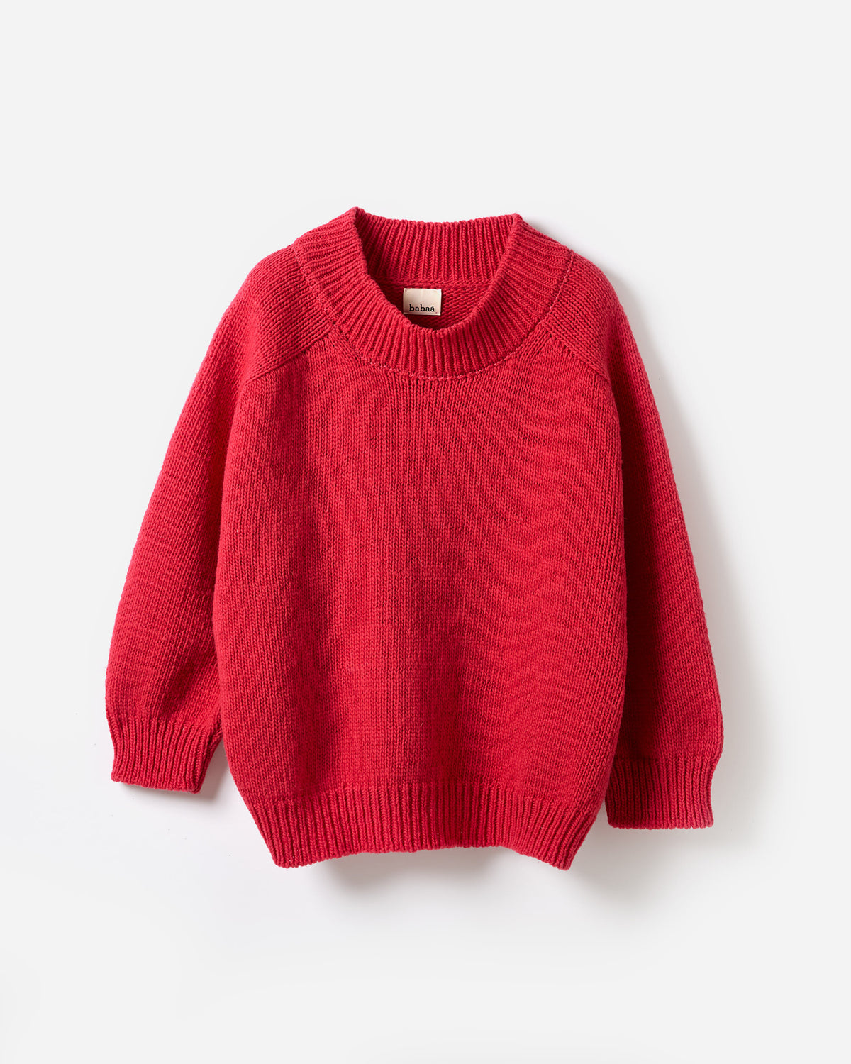 Woman wearing Babaà No51 Ruby jumper, showcasing the cozy, stylish silhouette in a vibrant red color.