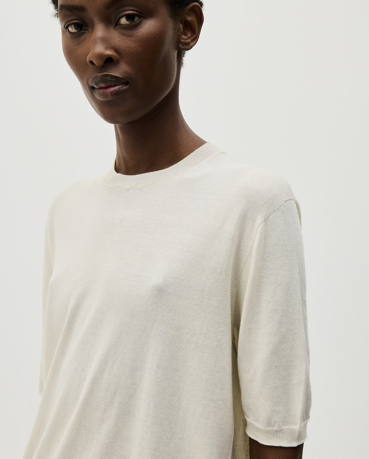 Woman wearing Babaà No59 natural jumper, showcasing a cozy, beige knit sweater with a relaxed fit and soft texture.