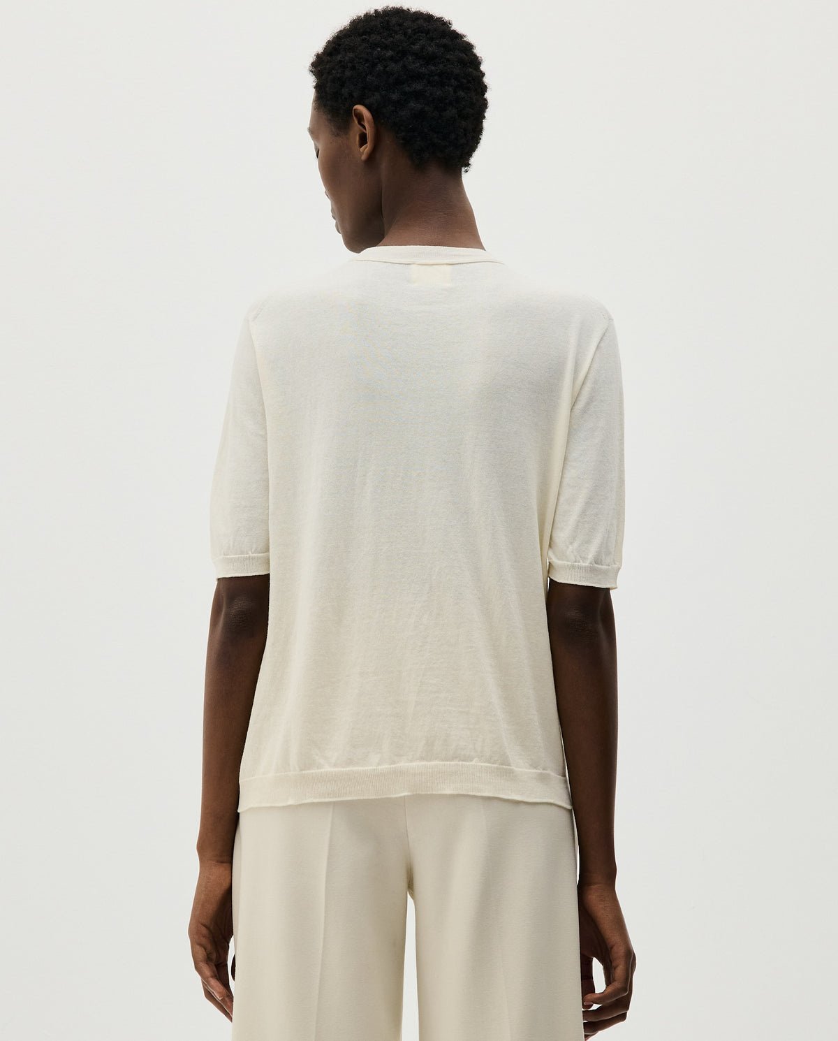 Woman wearing Babaà No59 Natural jumper, showcasing its cozy fit and neutral color in a casual setting.