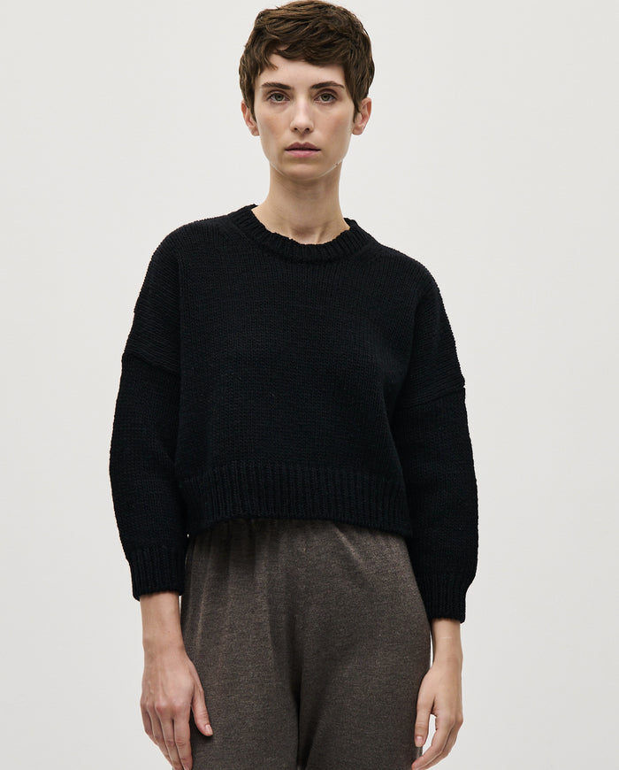 Black Babaà No61 women's jumper displayed on a hanger, showcasing its cozy knit fabric and classic design.