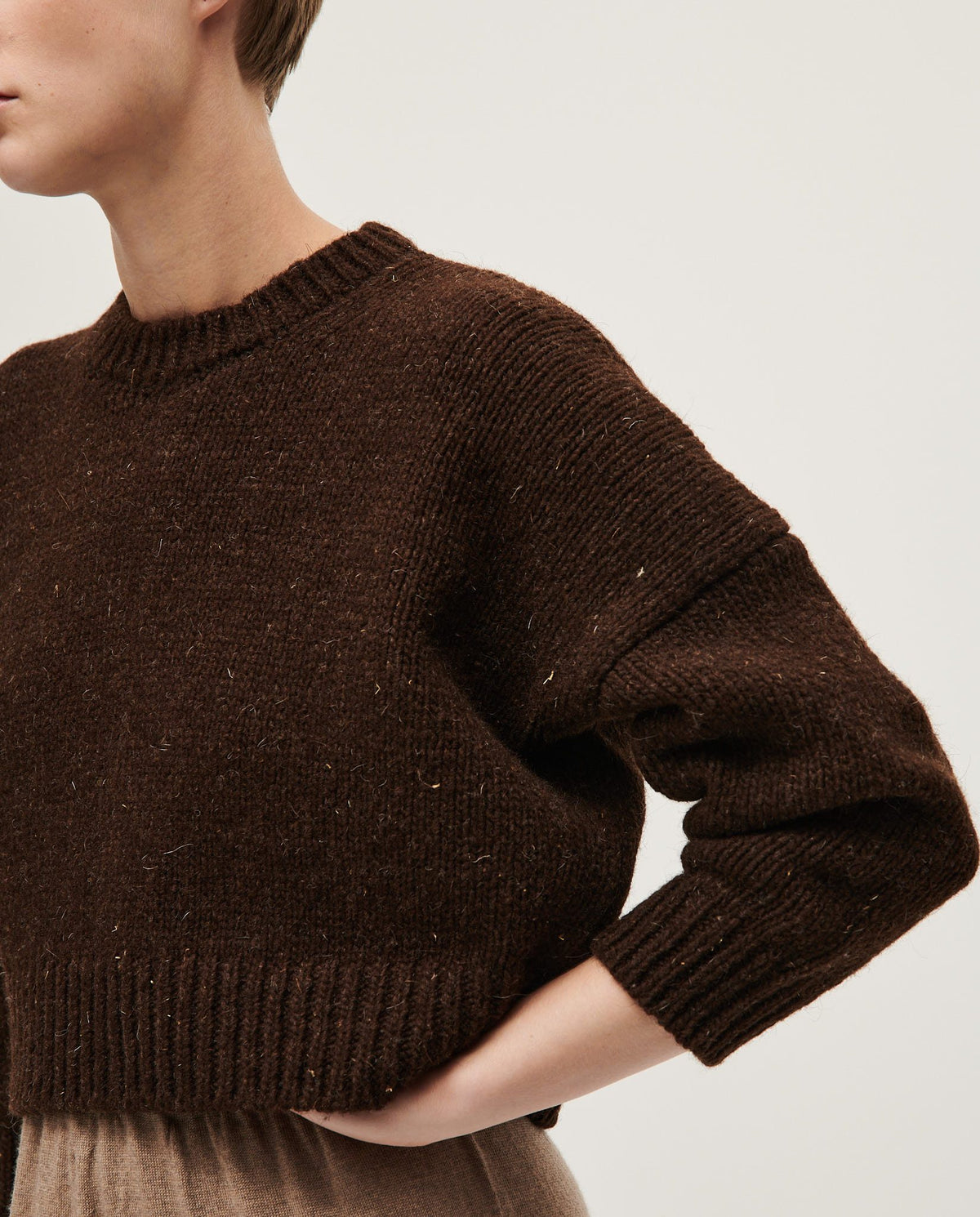 Woman wearing Babaà No61 Earth jumper, cozy knit in earthy tones, showcasing a stylish, relaxed fit for casual wear.