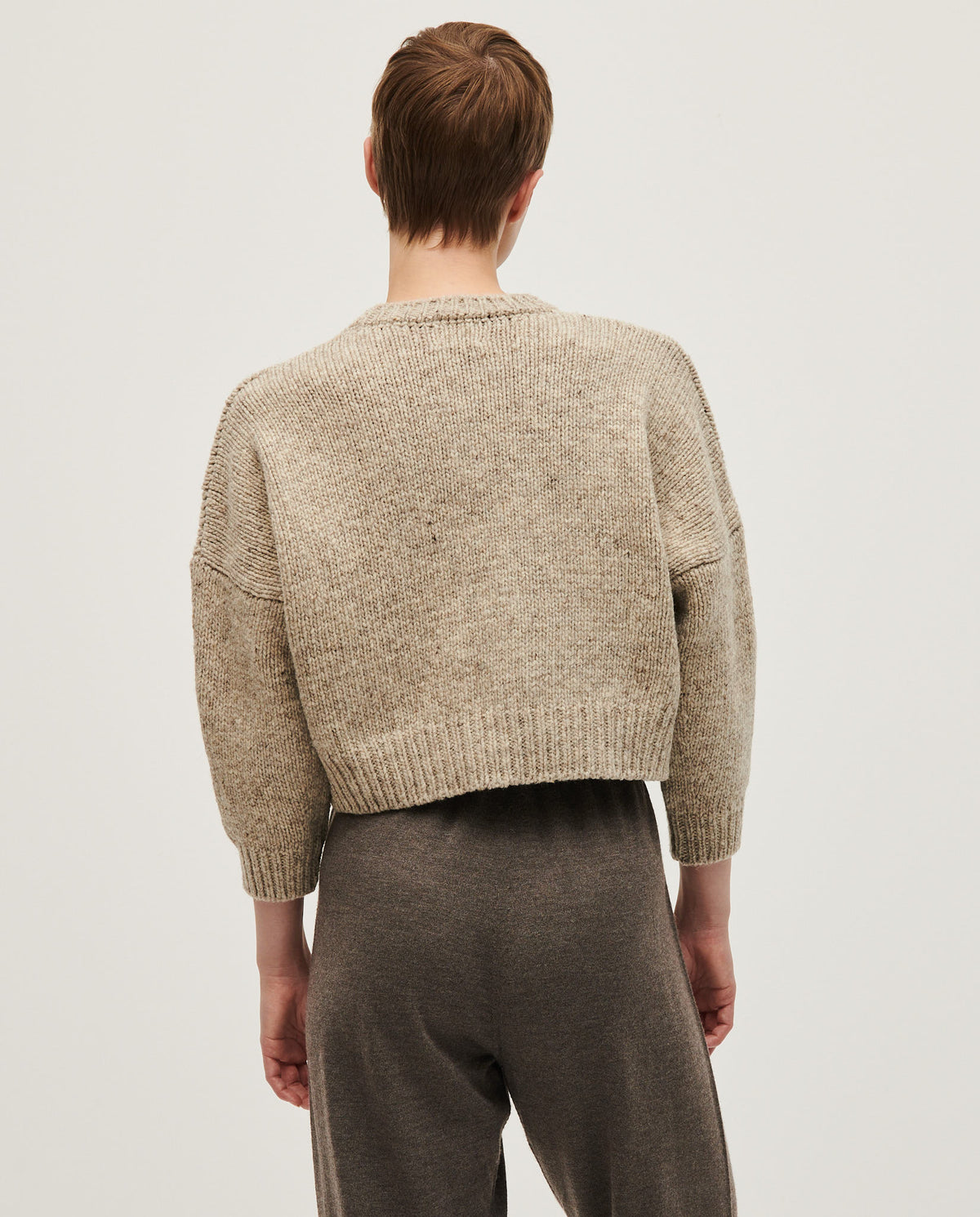 Woman wearing Babaà No61 Mist jumper, cozy knit sweater with a relaxed fit and soft, misty gray color.