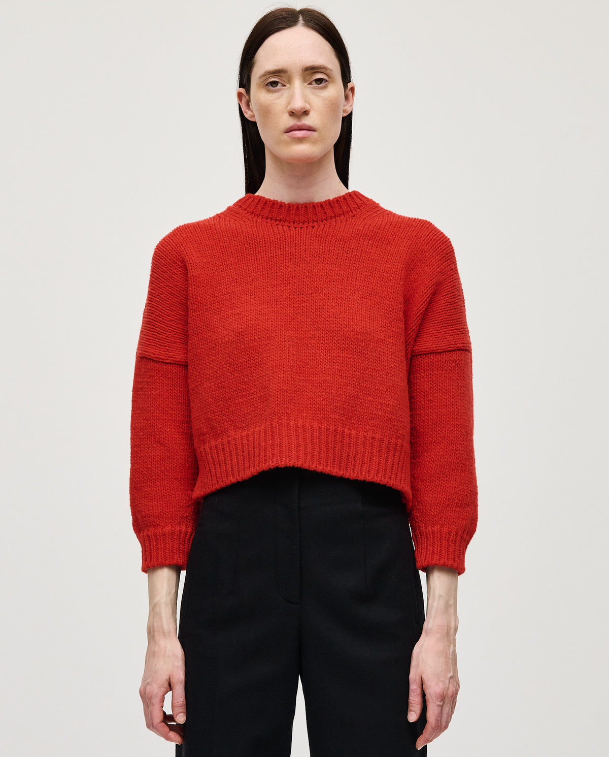 Babaà No61 red women's jumper, soft knit sweater with a cozy fit, shown on a woman in a casual indoor setting.