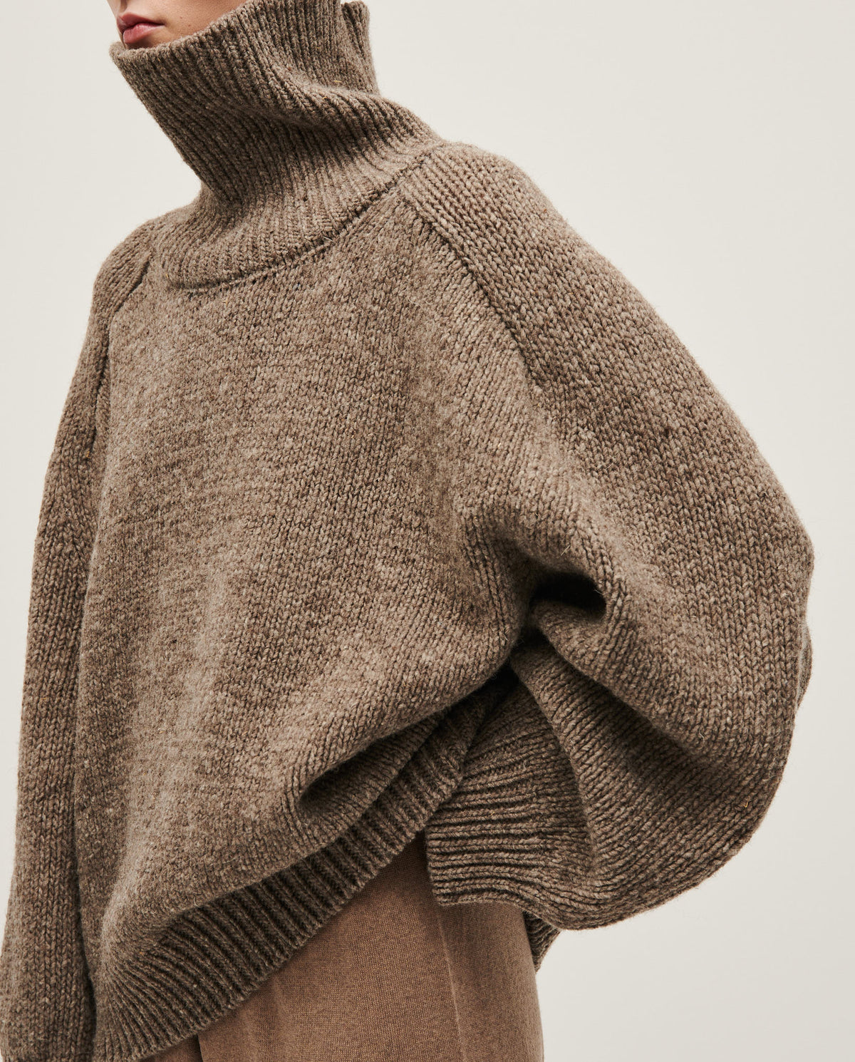 Woman wearing Babaà Jumper No67 in dark mist, cozy knit sweater with long sleeves and relaxed fit.
