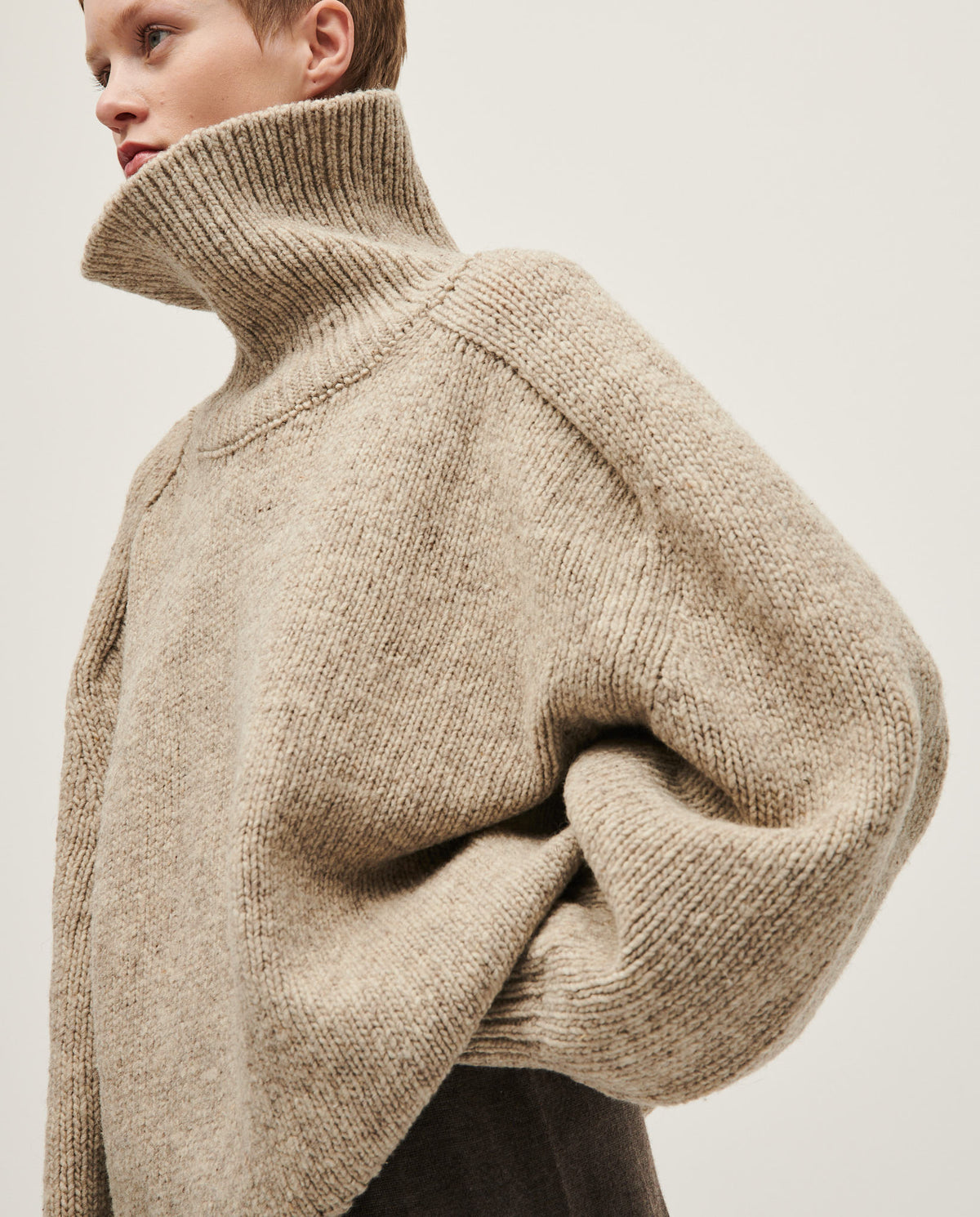 Babaà No67 Mist women's jumper featuring a cozy knit design in soft pastel tones, worn by a woman in a stylish casual setting.