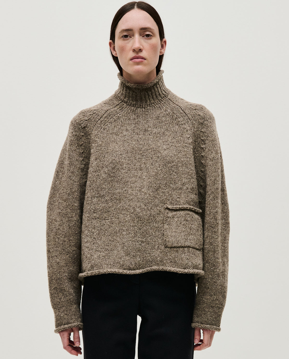 Woman wearing Babaà No70 dark mist jumper, showcasing its cozy fit and soft knit fabric in a casual setting.