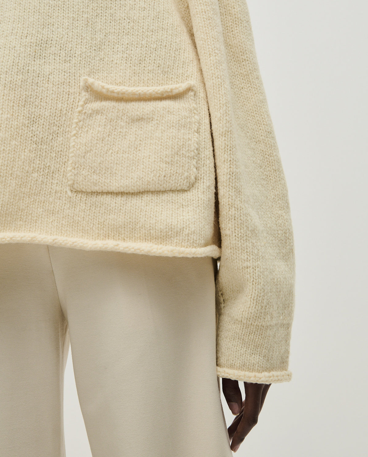 Woman wearing Babaà No70 Natural jumper, showcasing its cozy, neutral-colored knit design and relaxed fit.