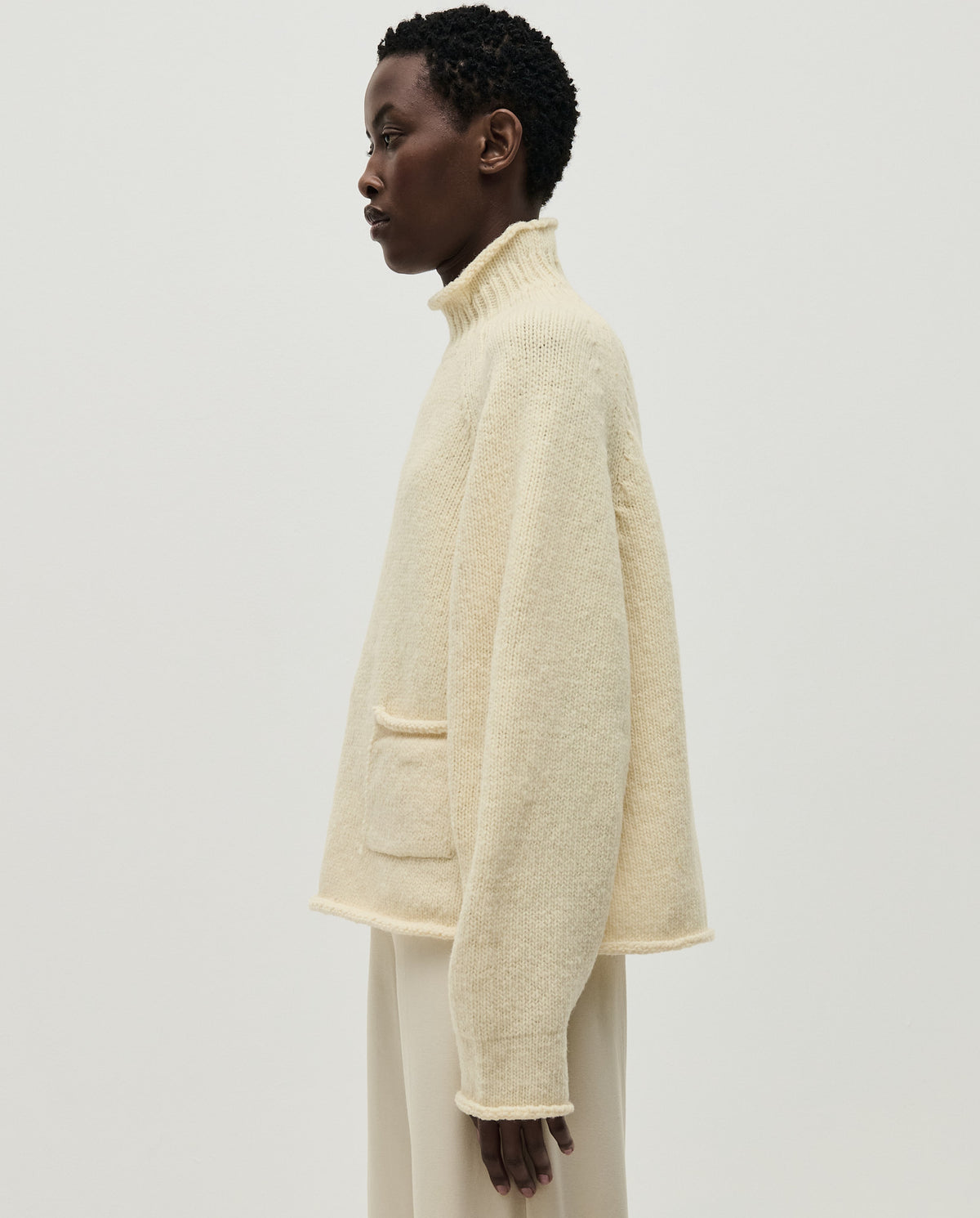 Woman wearing Babaà No70 Natural jumper, showcasing its cozy fit and neutral beige color, perfect for casual or stylish wear.