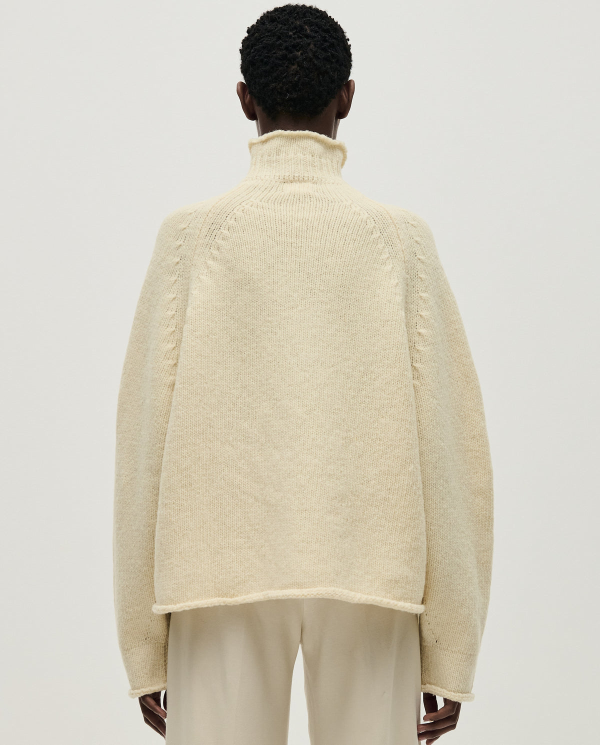 Woman wearing Babaà No70 Natural jumper, showcasing its cozy knit texture and relaxed fit in a casual setting.