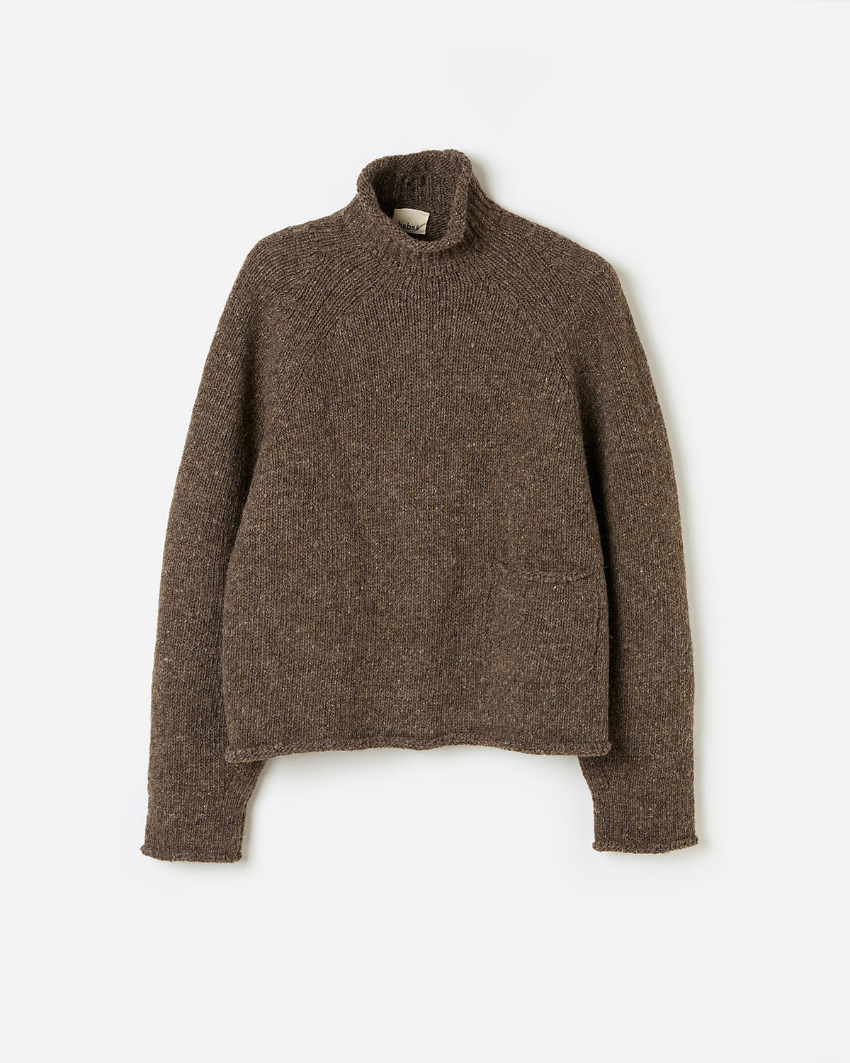Silhouette of a woman wearing the Babaà No70 oak jumper, showcasing its relaxed fit and cozy knit texture.