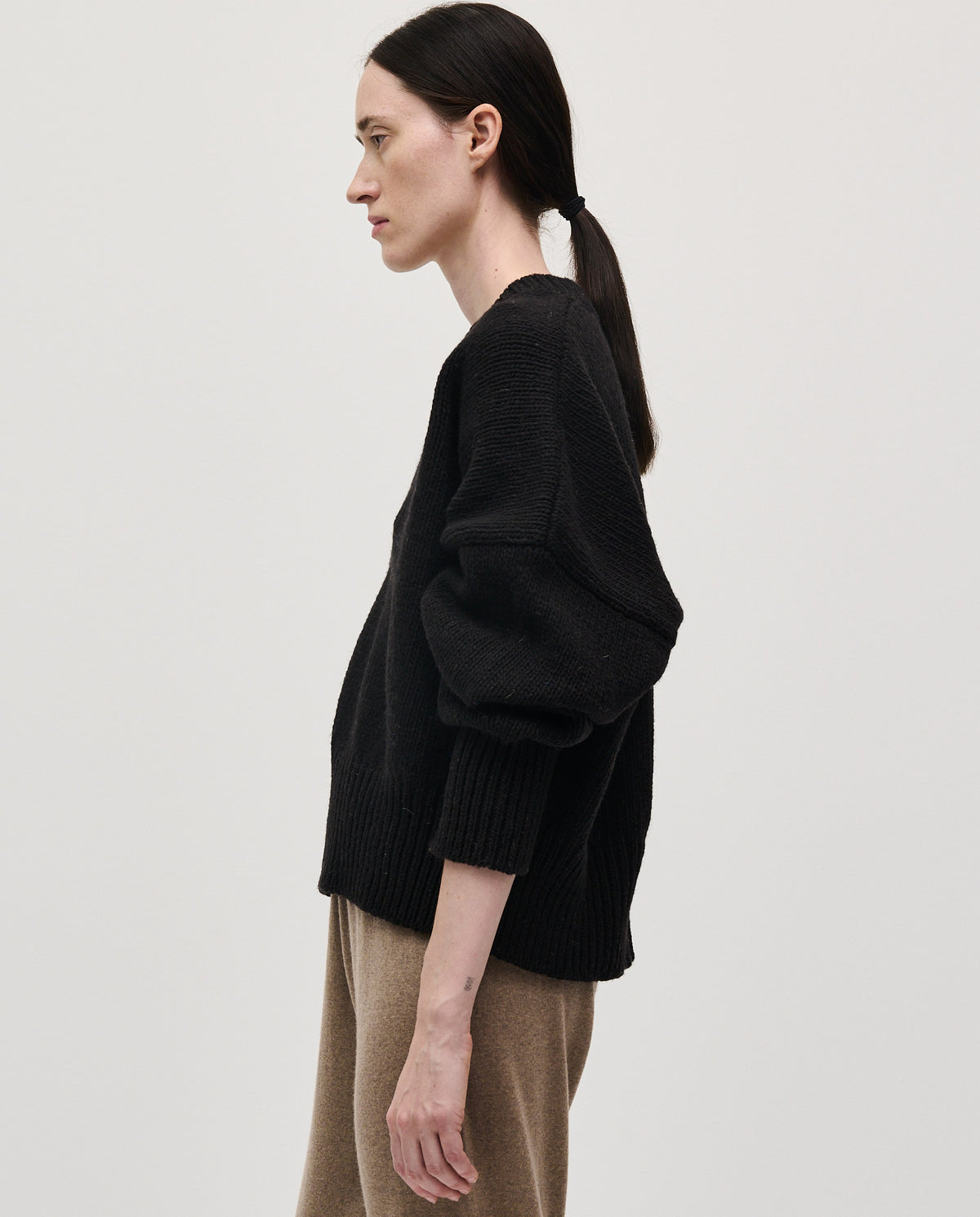 Black Babaà Jumper No75 worn by a woman, featuring a comfortable, stylish knit design perfect for casual wear.