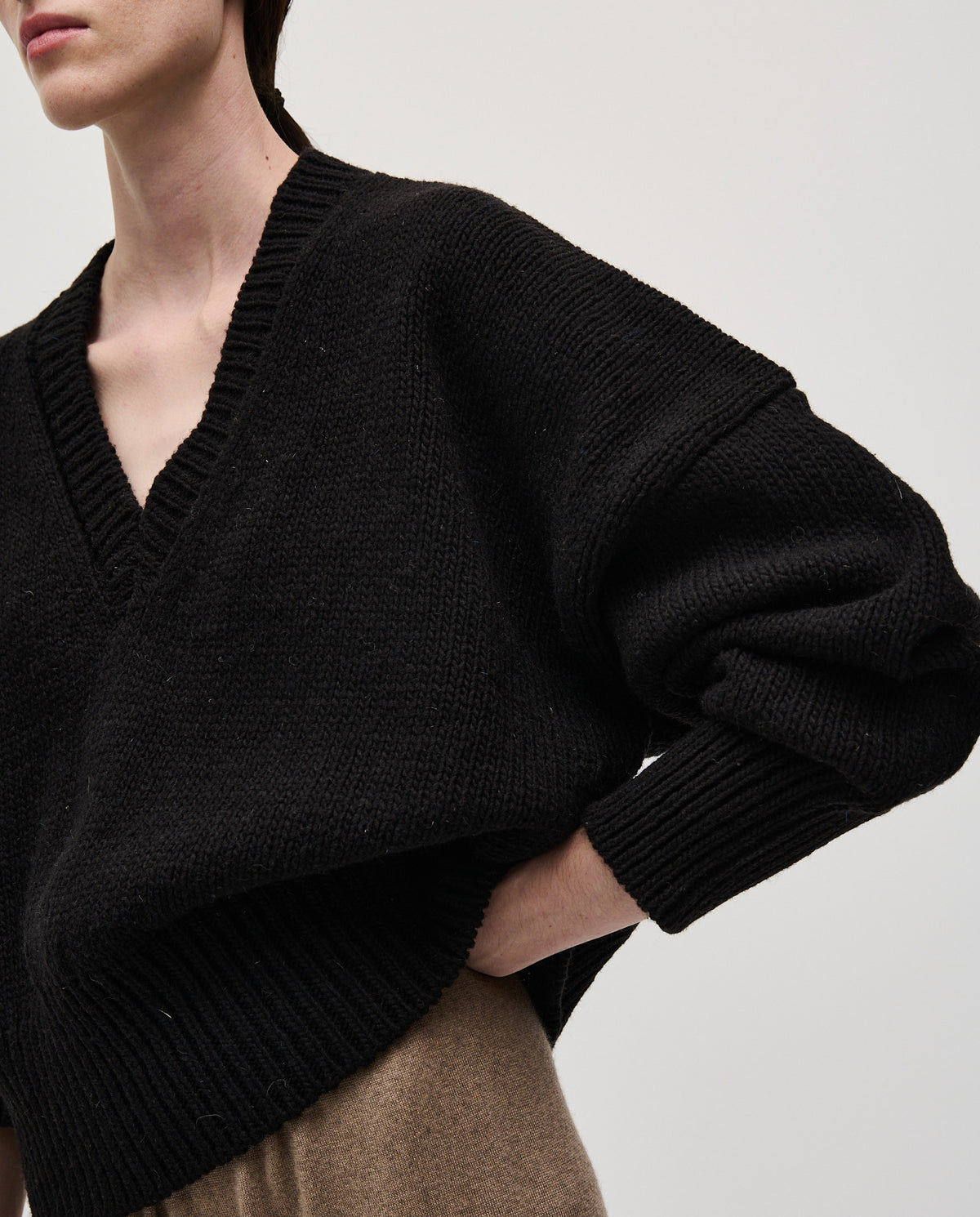 Black Babaà No75 jumper for women, featuring a cozy, stylish knit design, shown on a woman in a relaxed pose.