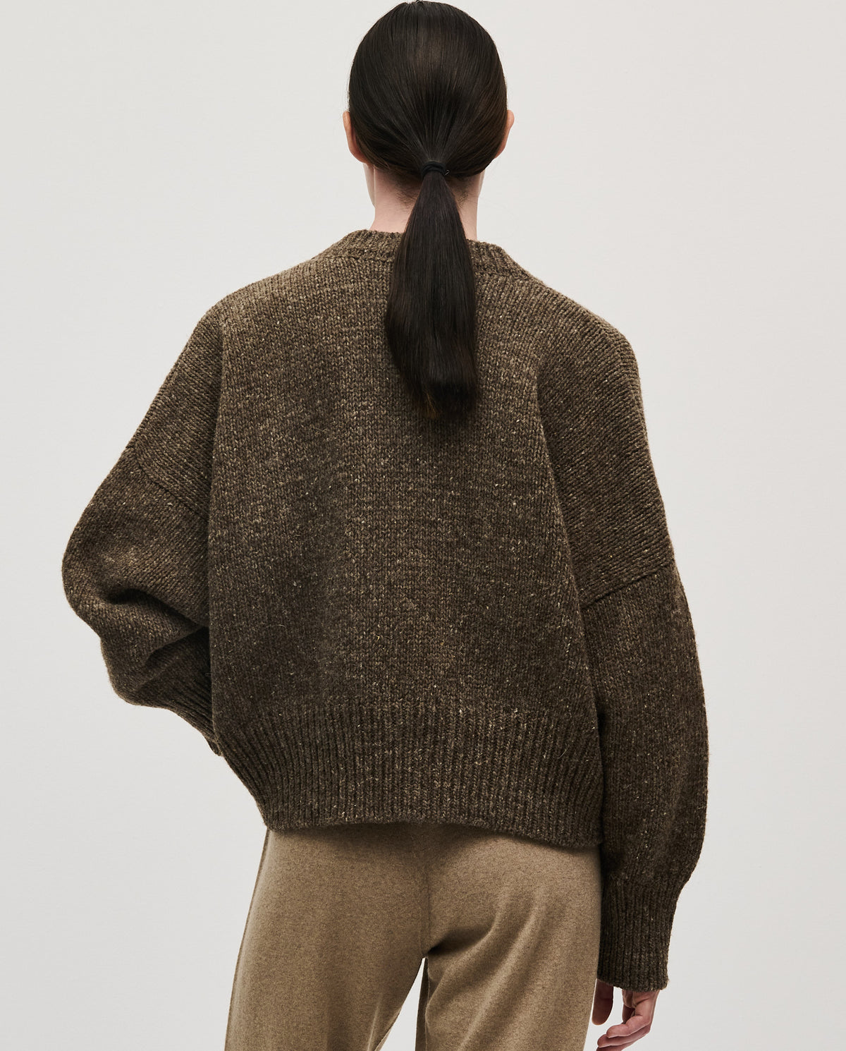 Woman wearing Babaà No75 Oak jumper, featuring a cozy knit design in a warm oak color.