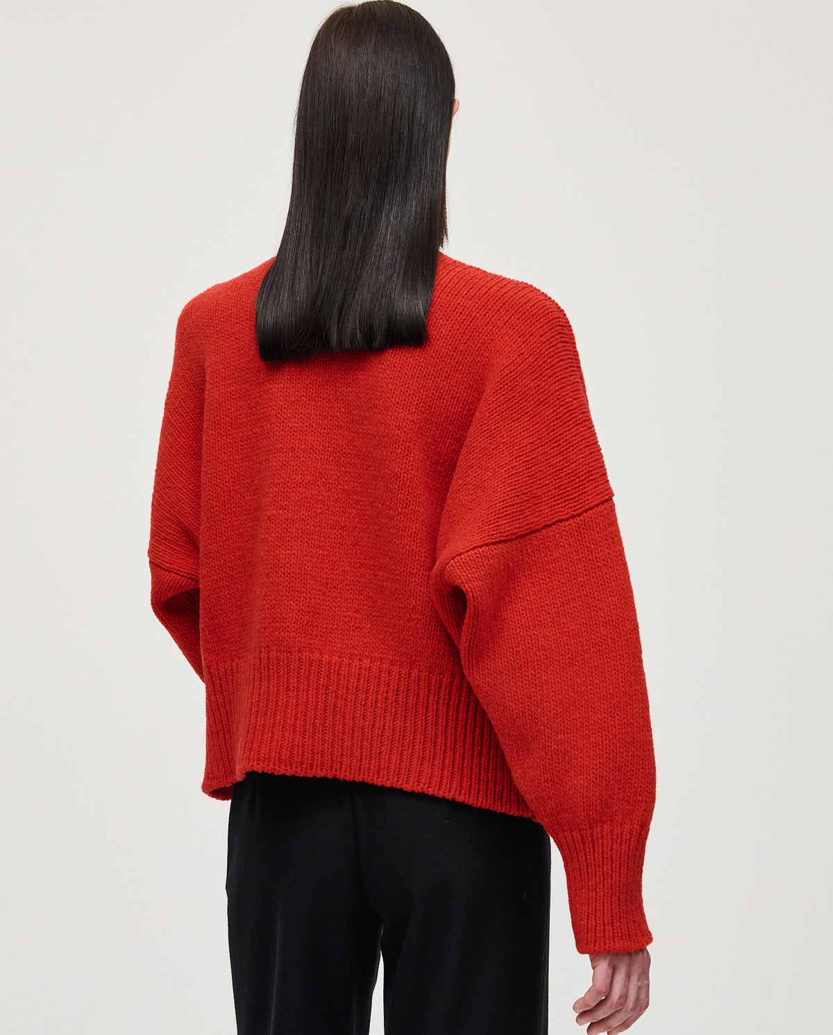 Red Babaà Jumper No75 worn by a woman, showcasing a stylish knit sweater with a high neckline and cozy fit.
