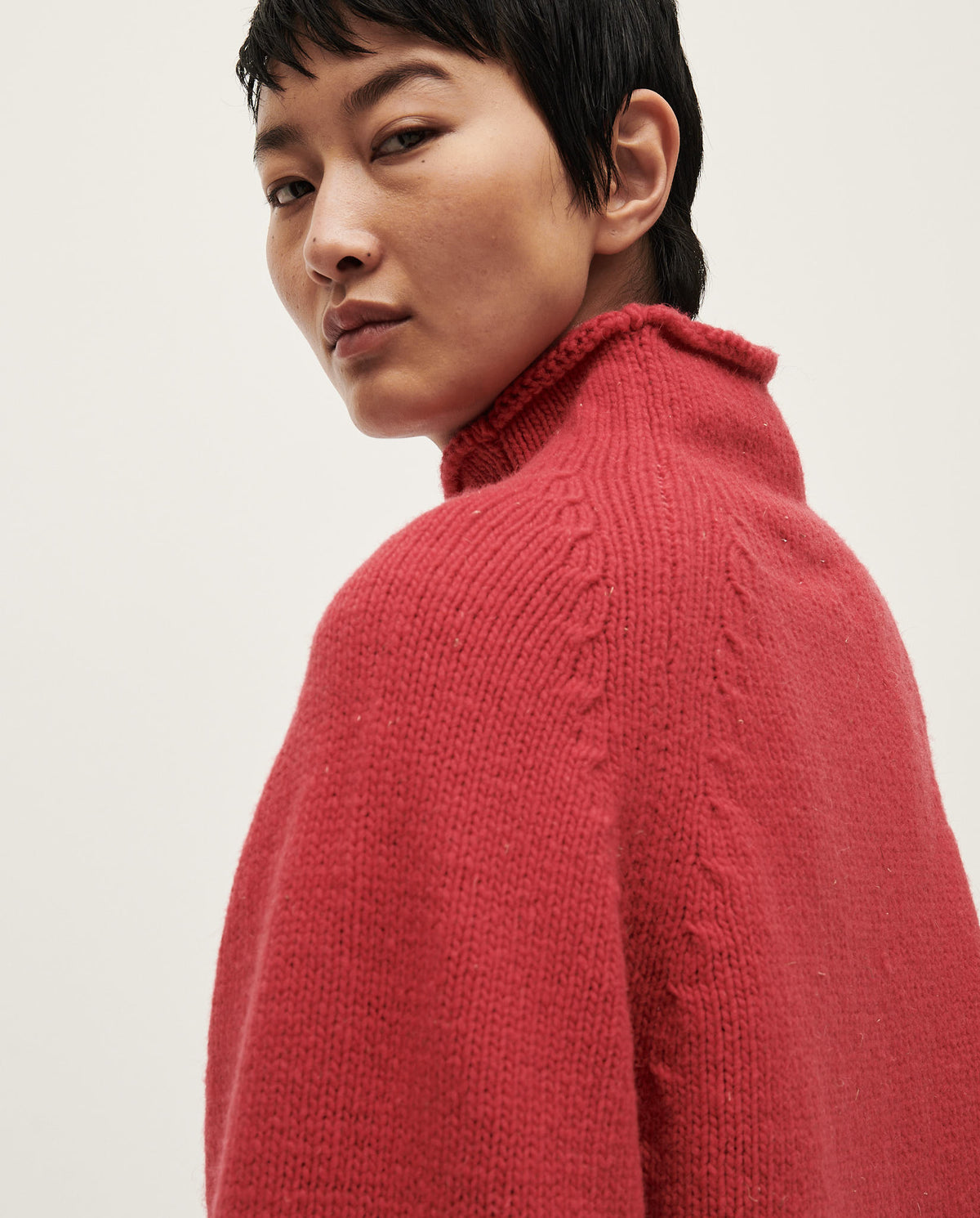 Woman wearing Babaà No81 Ruby jumper, featuring a cozy, vibrant red knit sweater with long sleeves and a relaxed fit.