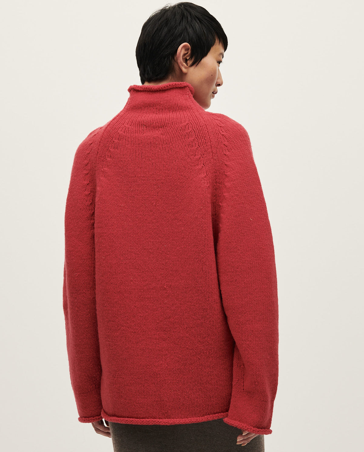 Woman wearing Babaà No81 Ruby jumper, featuring a cozy, vibrant red knit with a relaxed fit and stylish design.