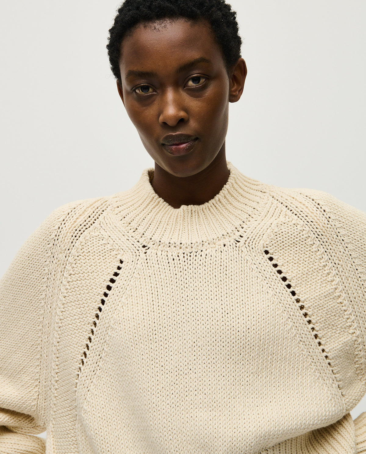 Woman wearing Babaà No86 natural jumper, showcasing its cozy, relaxed fit in a neutral, earthy tone.