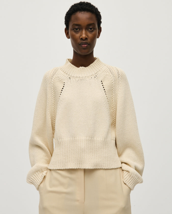 Woman wearing Babaà No86 Natural jumper, showcasing its cozy knit texture and relaxed fit in a casual setting.
