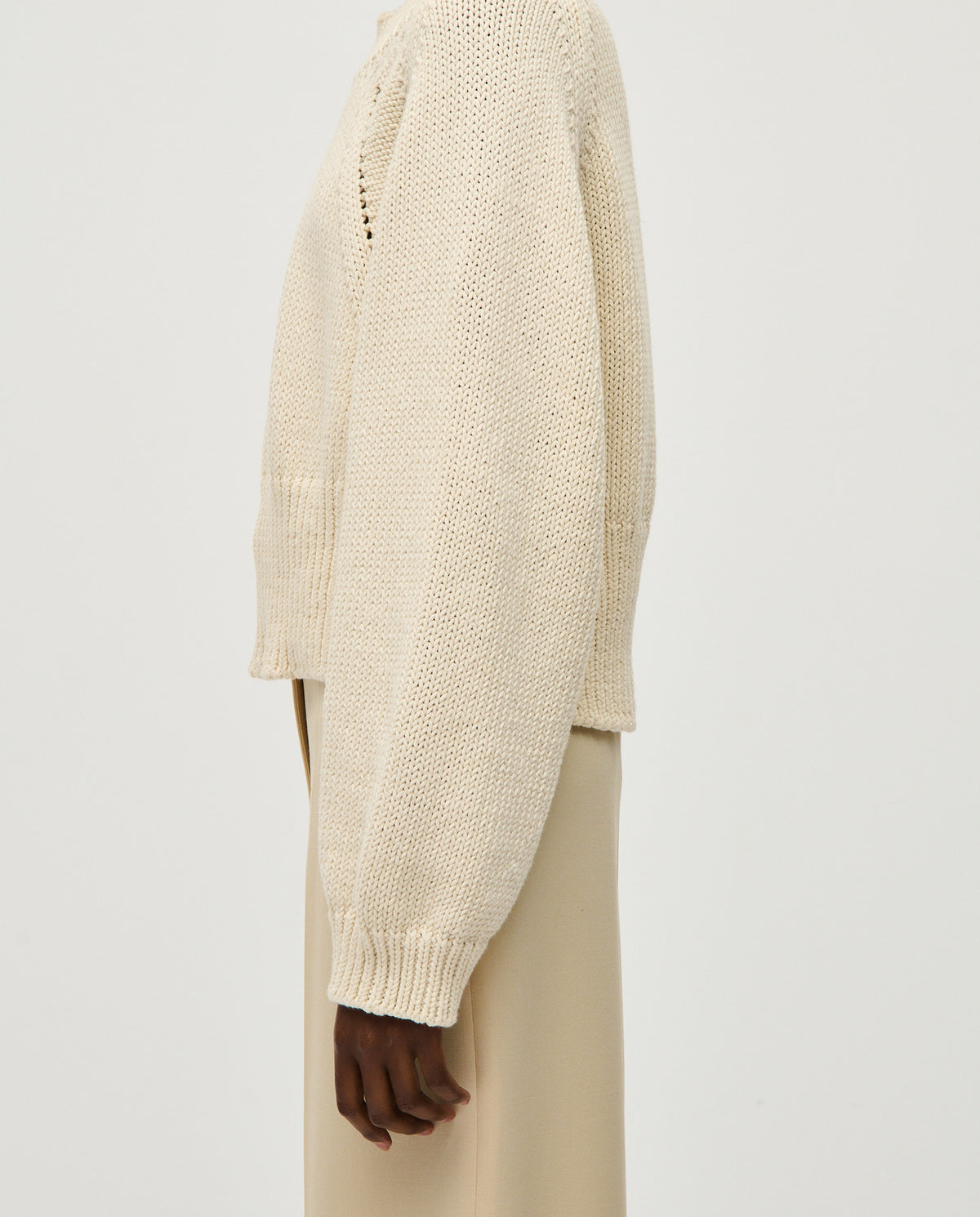 Woman wearing Babaà No86 natural jumper, soft beige knit sweater with a relaxed fit and long sleeves, styled casually.