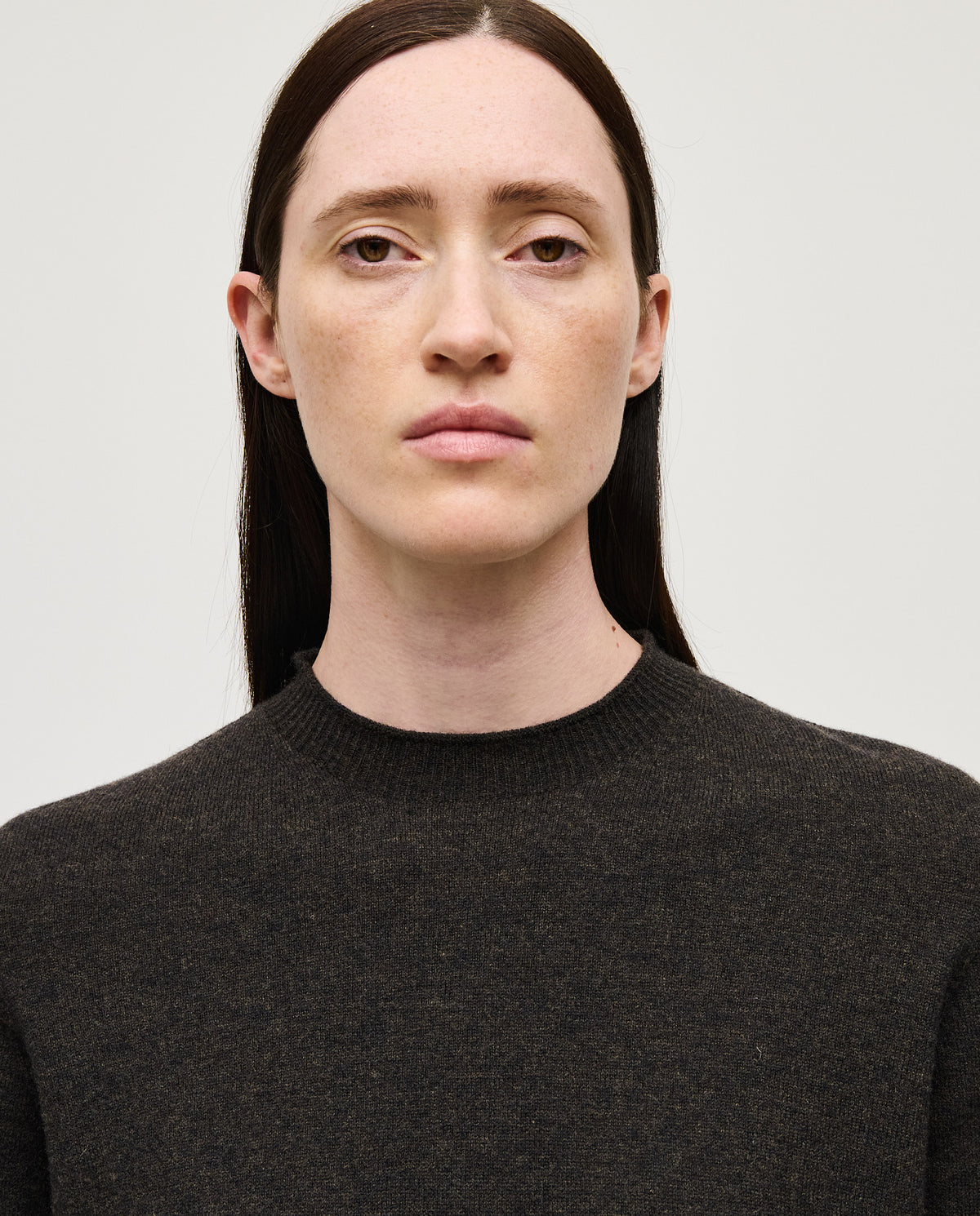 Woman wearing Babaà Jumper No89 Mica, cozy knit sweater in earthy tones, styled casually indoors.