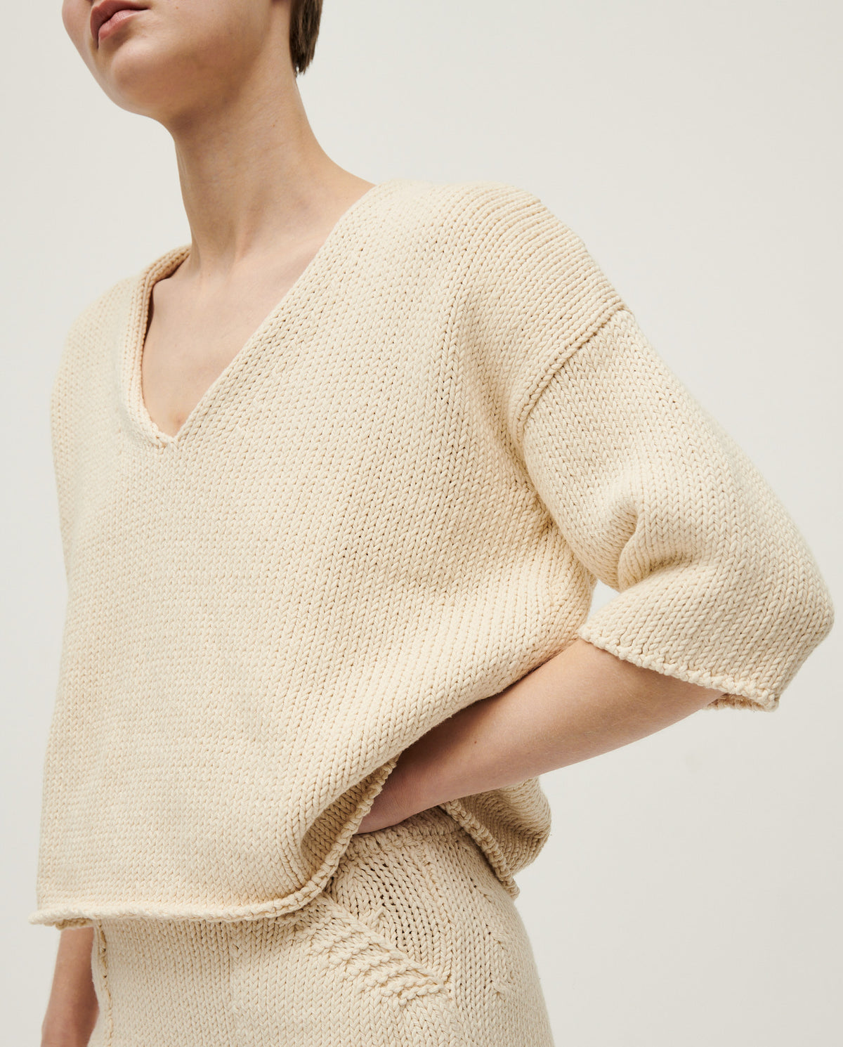 Woman wearing Babaà No9 Natural jumper, featuring a cozy, neutral-toned knit sweater with a relaxed fit and textured fabric.
