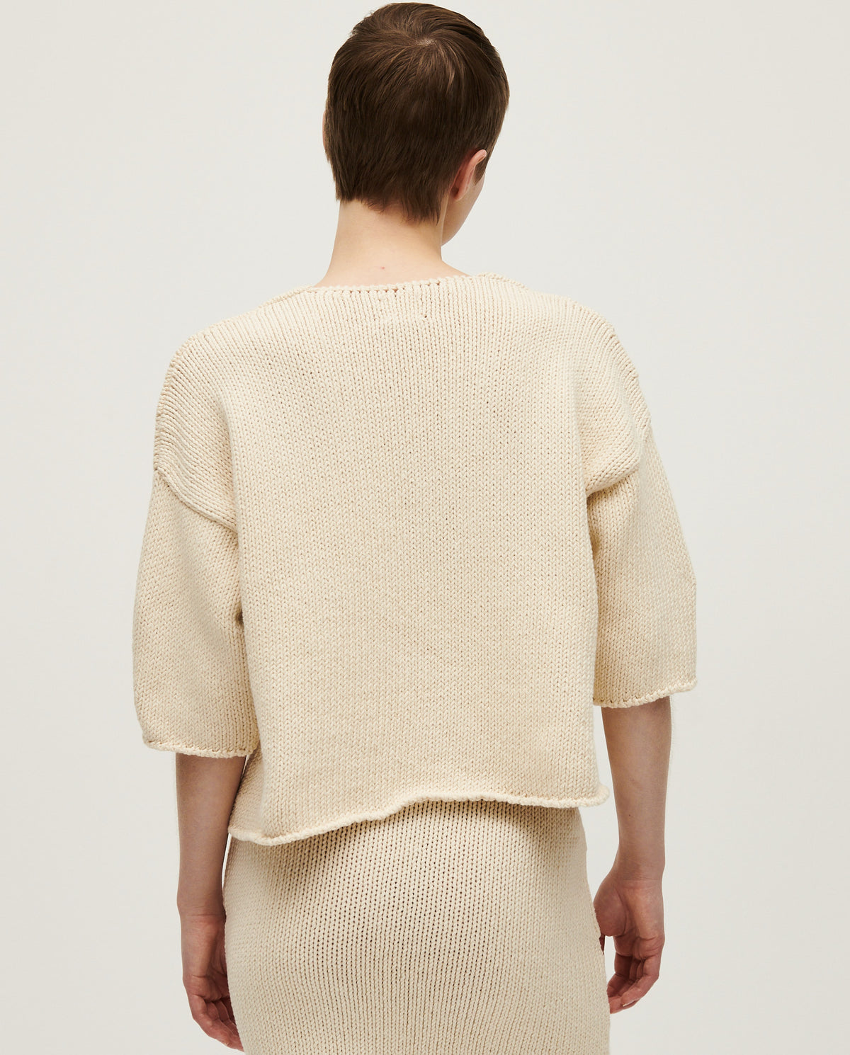 Woman wearing Babaà No9 Natural jumper, cozy knit sweater in soft beige, styled casually with long sleeves and a relaxed fit.