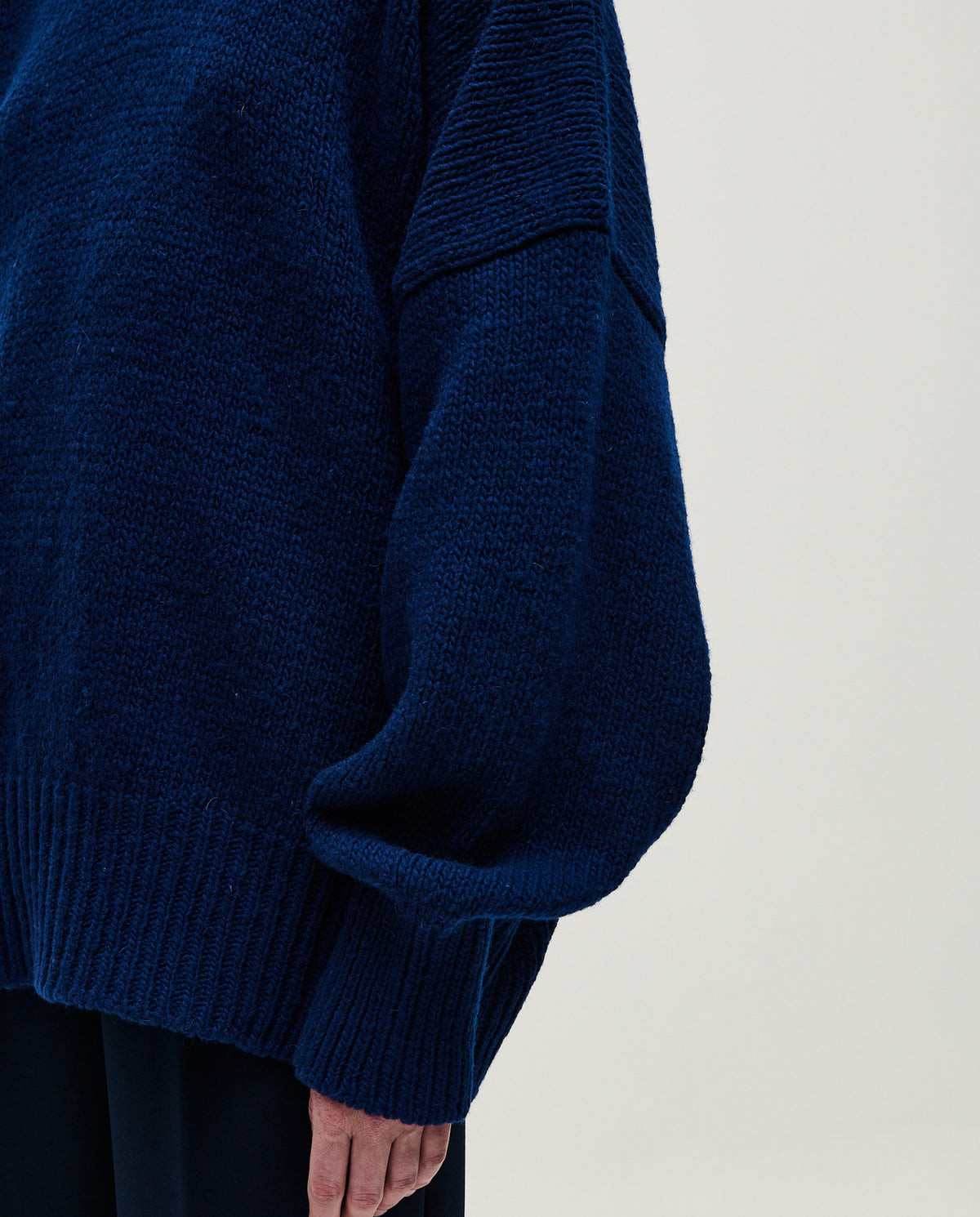 Navy jumper No90 by Babaà worn by a woman, showcasing a cozy knit sweater with a relaxed fit and ribbed cuffs.