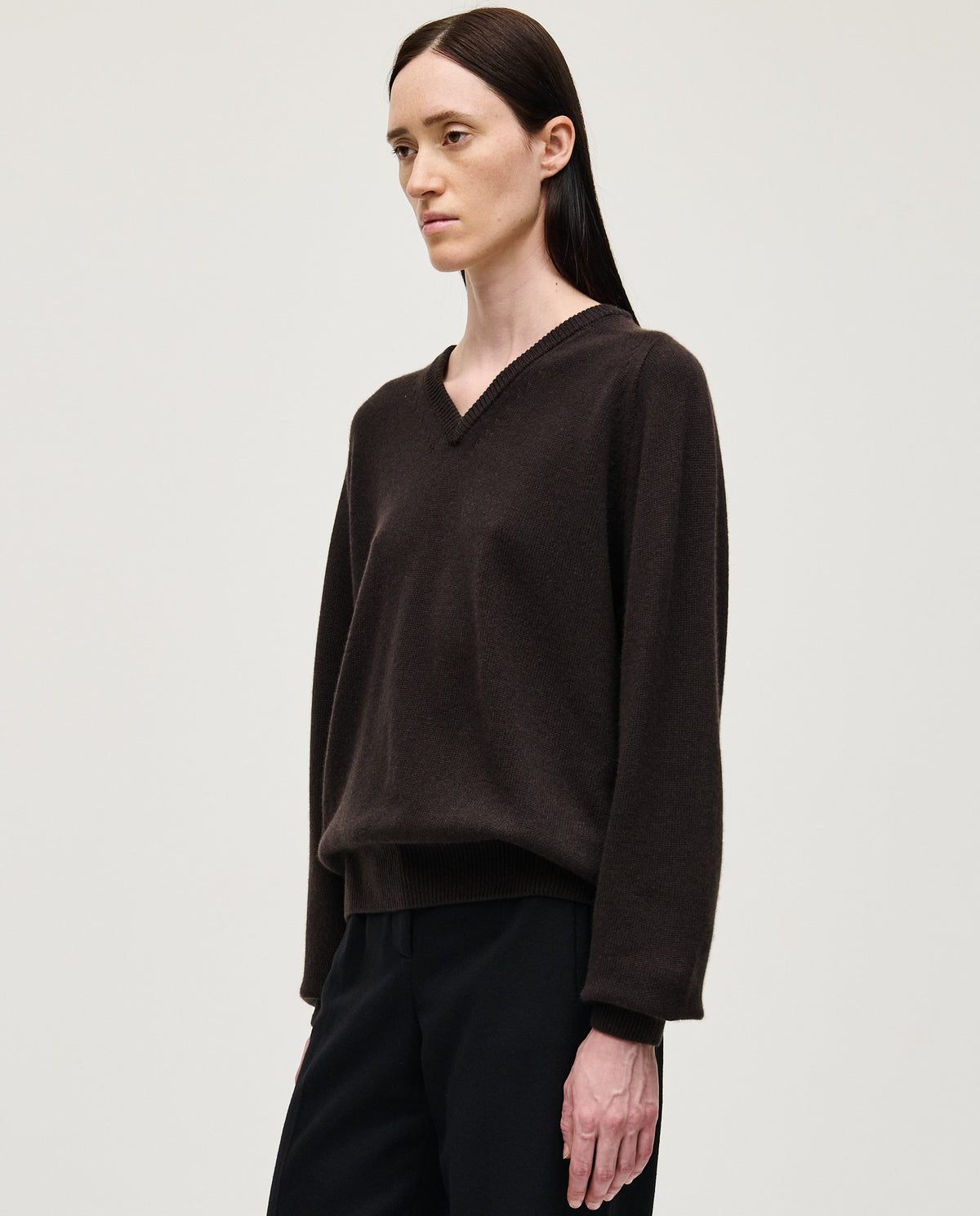 Black Babaà No91 Blackwood jumper worn by a woman, featuring a cozy fit and stylish design in a natural outdoor setting.