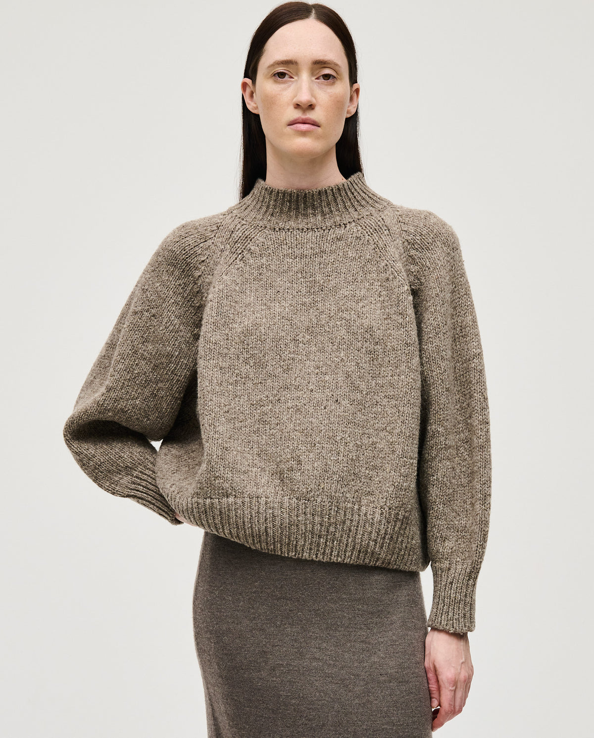 Woman wearing Babaà No95 Dark Mist jumper, showing the cozy, fitted knit sweater in soft dark mist color.