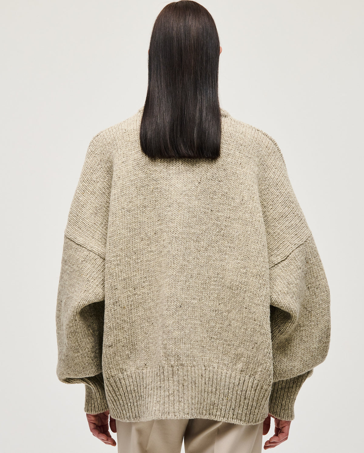 Woman wearing Babaà No97 Mist jumper, cozy knit sweater with a relaxed fit, in soft mist color, perfect for casual wear.